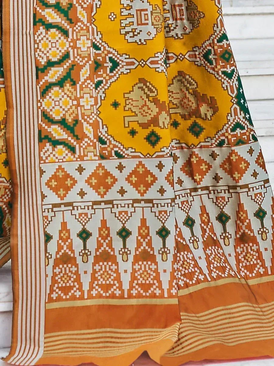 Vibrant yellow and orange ethnic saree with intricate geometric and animal motifs, perfect for traditional Indian wear.