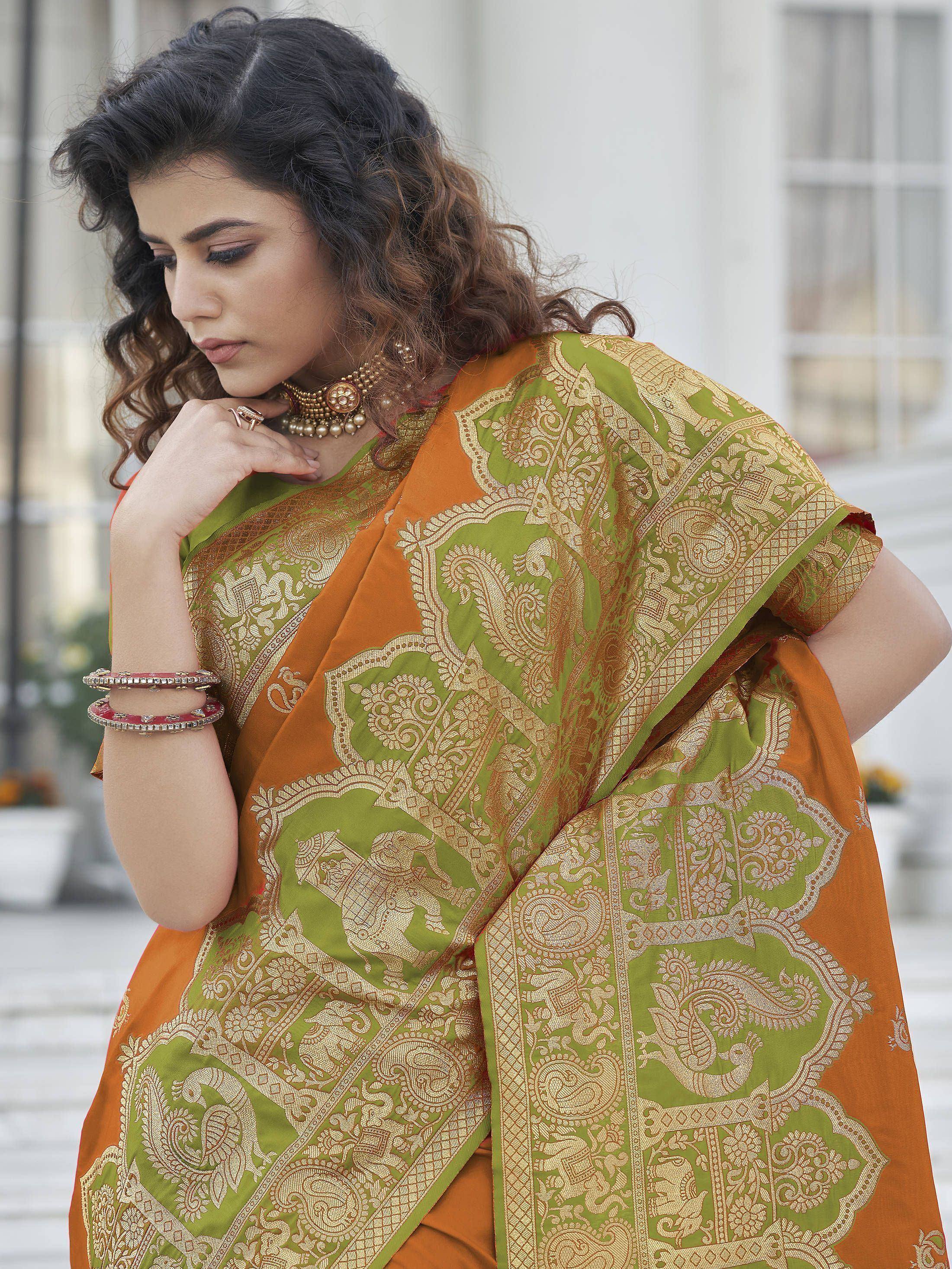 Woman in orange and green designer saree with gold paisley print, ethnic wear for festive occasions