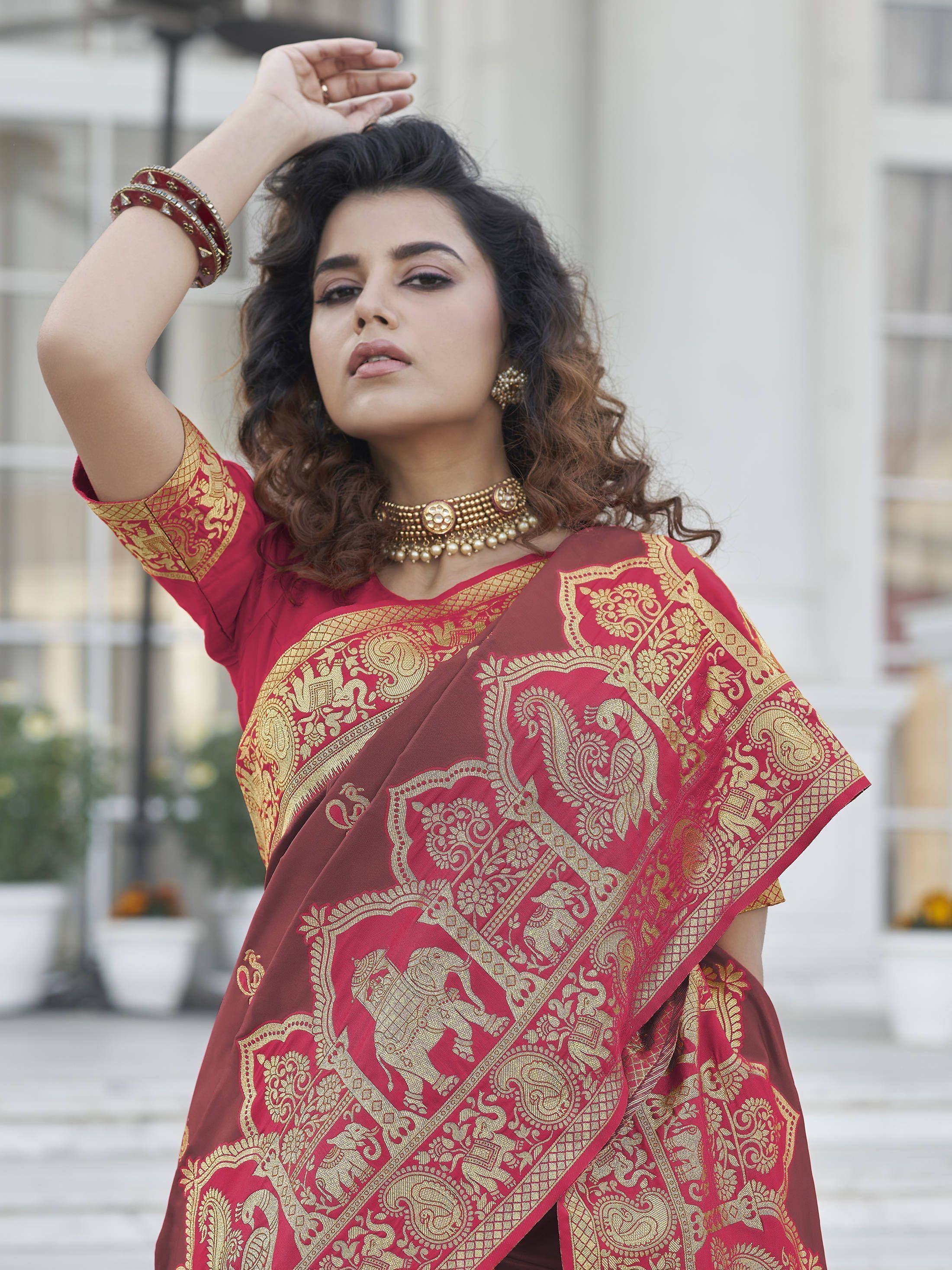 Red and gold embroidered saree with peacock and elephant motifs, styled with traditional jewelry