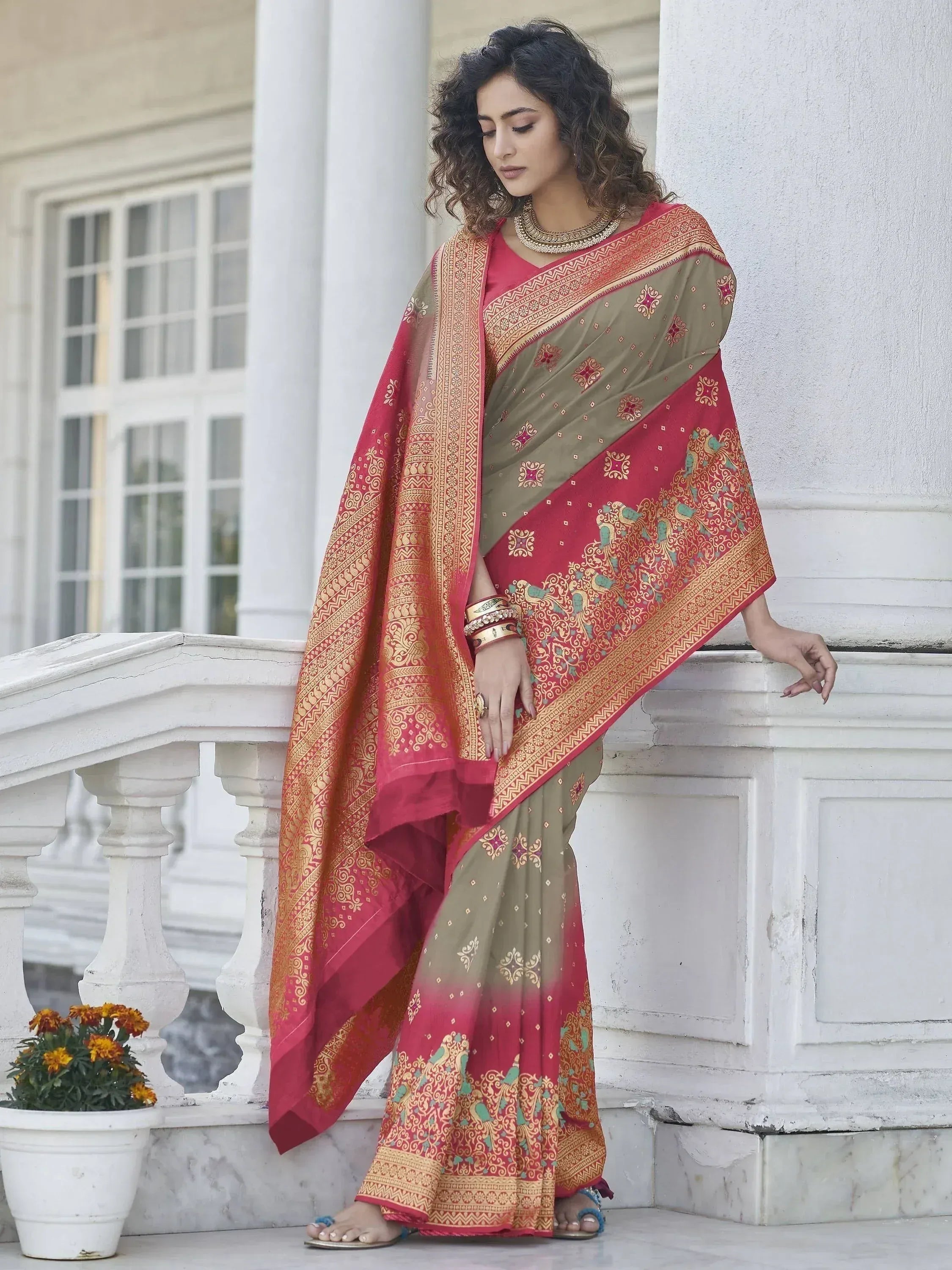Elegant woman in traditional Indian saree with red and olive green hues, intricate gold embroidery, and peacock motifs, styled for festive occasions.