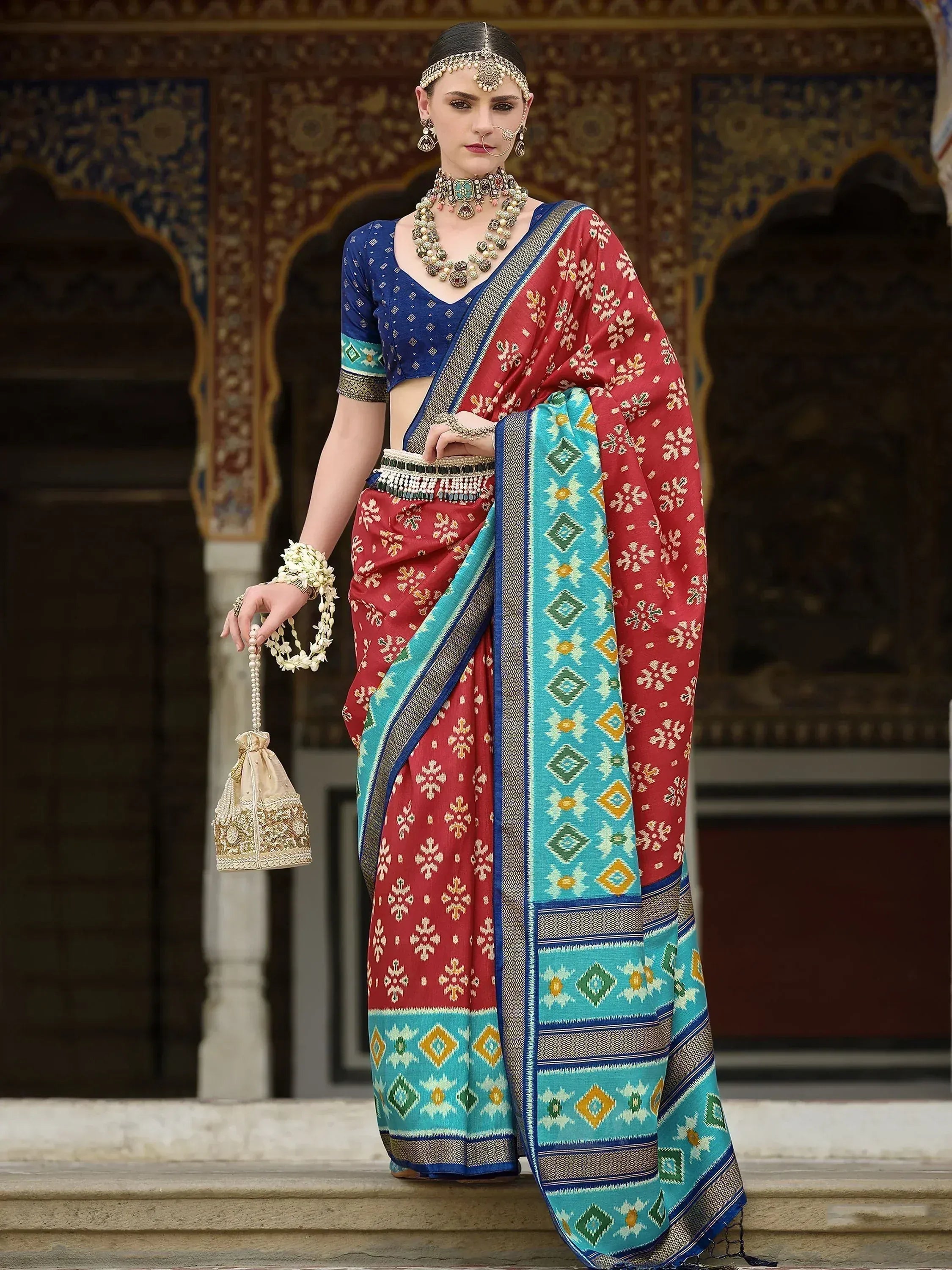 Red and turquoise printed saree with blue blouse, traditional Indian ethnic wear, temple backdrop