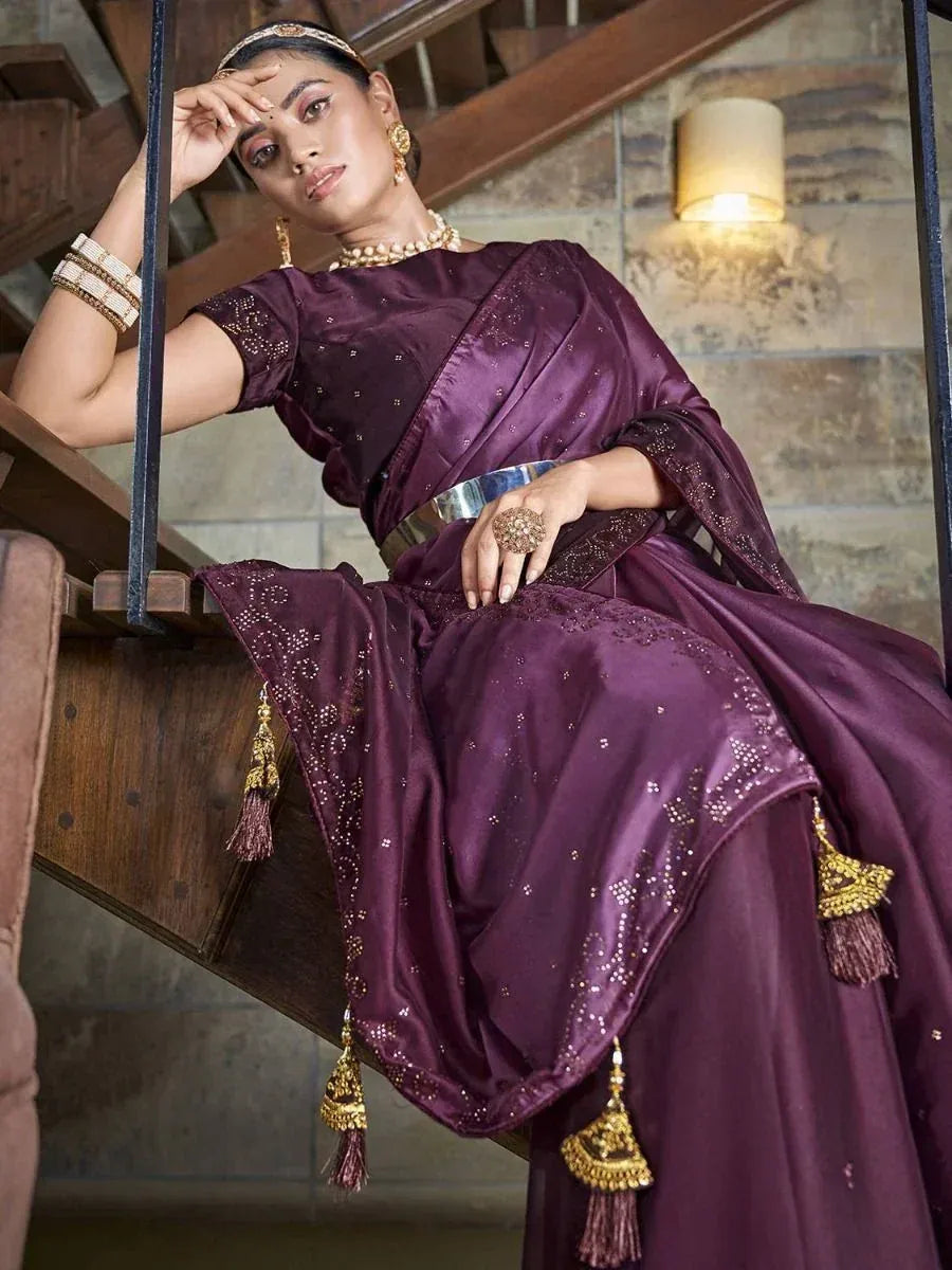 Elegant purple designer saree with gold embroidery and tassels, styled with traditional jewelry for ethnic occasions.