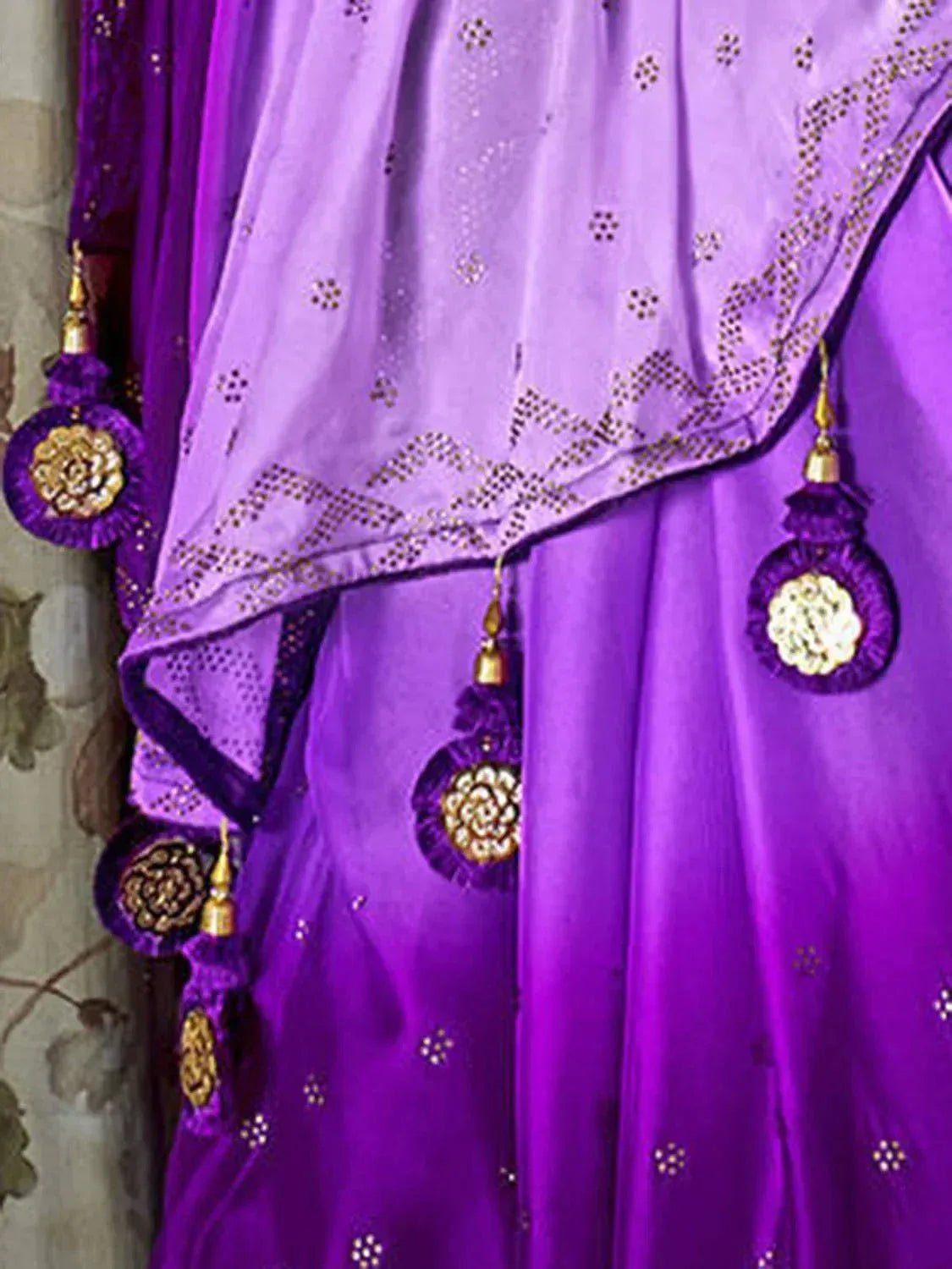 Purple ethnic saree with gold embroidery and tassel details, perfect for Indian occasions
