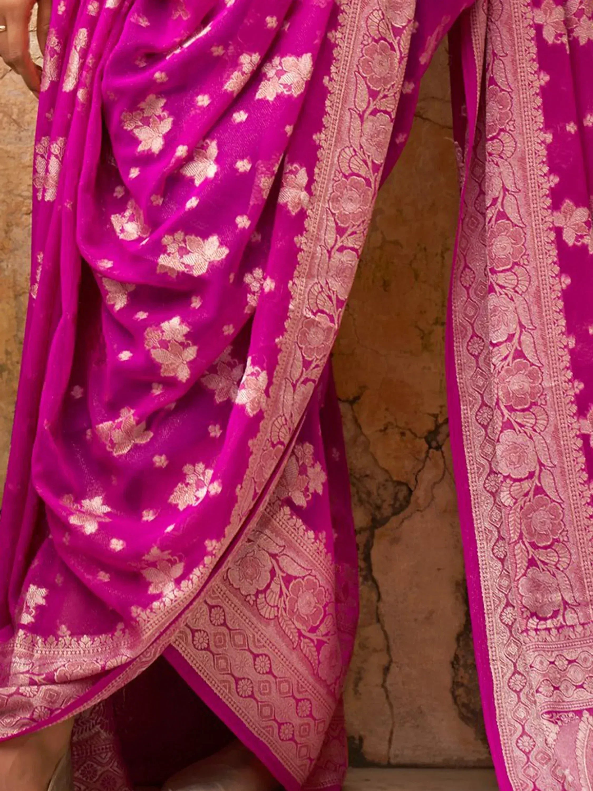 Vibrant pink ethnic saree with gold floral zari work and intricate border, perfect for Indian celebrations