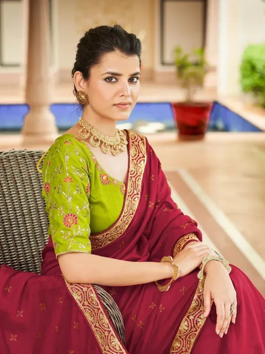 Woman in maroon saree with gold border and green embroidered blouse, traditional Indian ethnic wear
