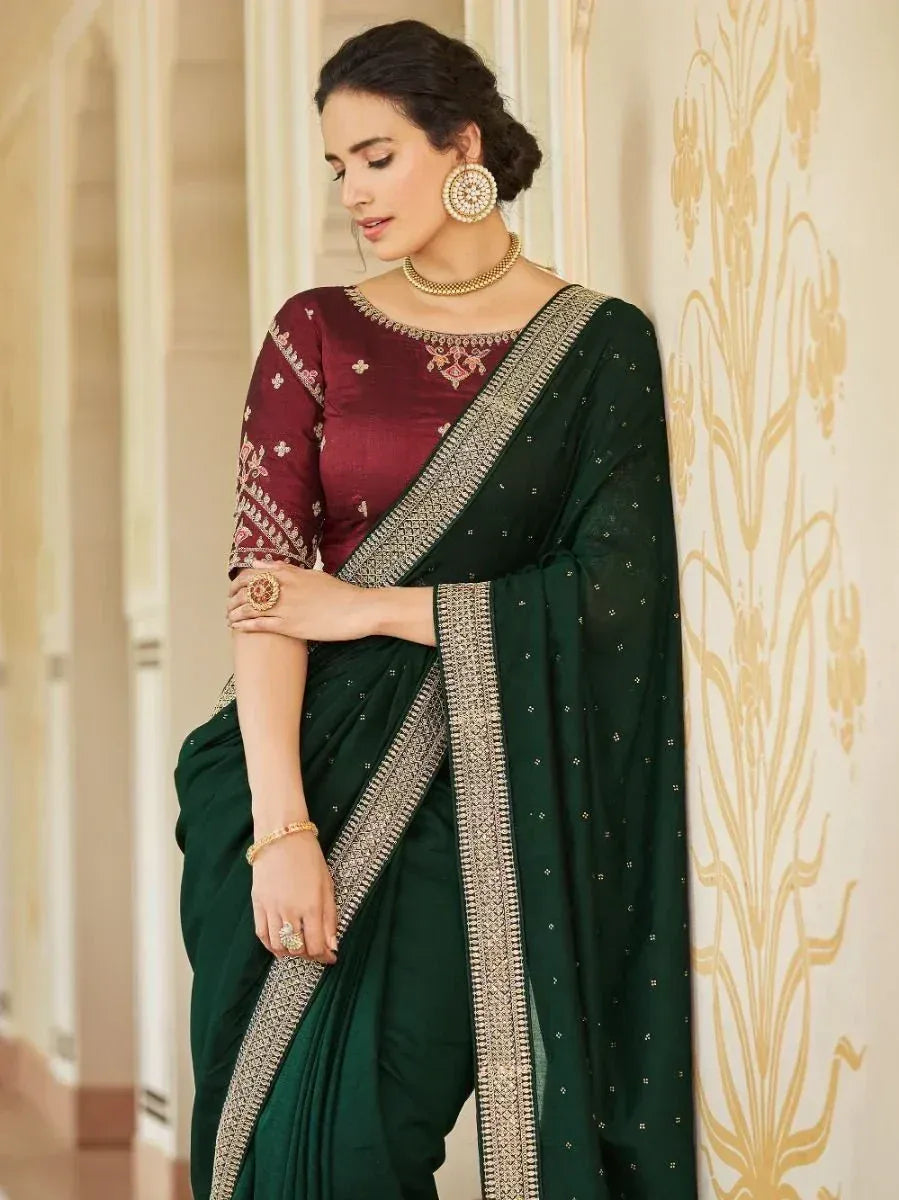 Elegant green saree with gold border and maroon embroidered blouse, styled with traditional jewelry