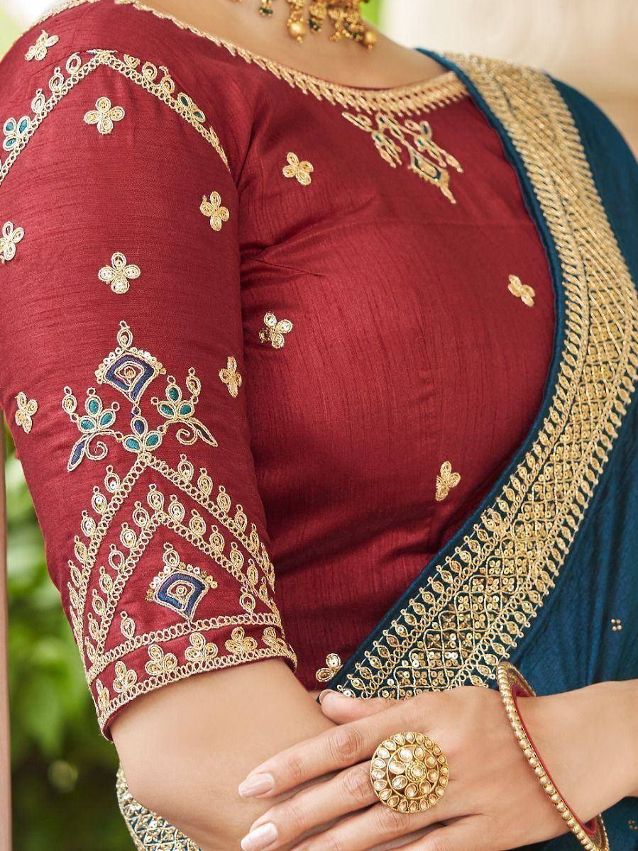 Maroon embroidered blouse with gold and blue detailing, paired with a navy saree for Indian ethnic wear