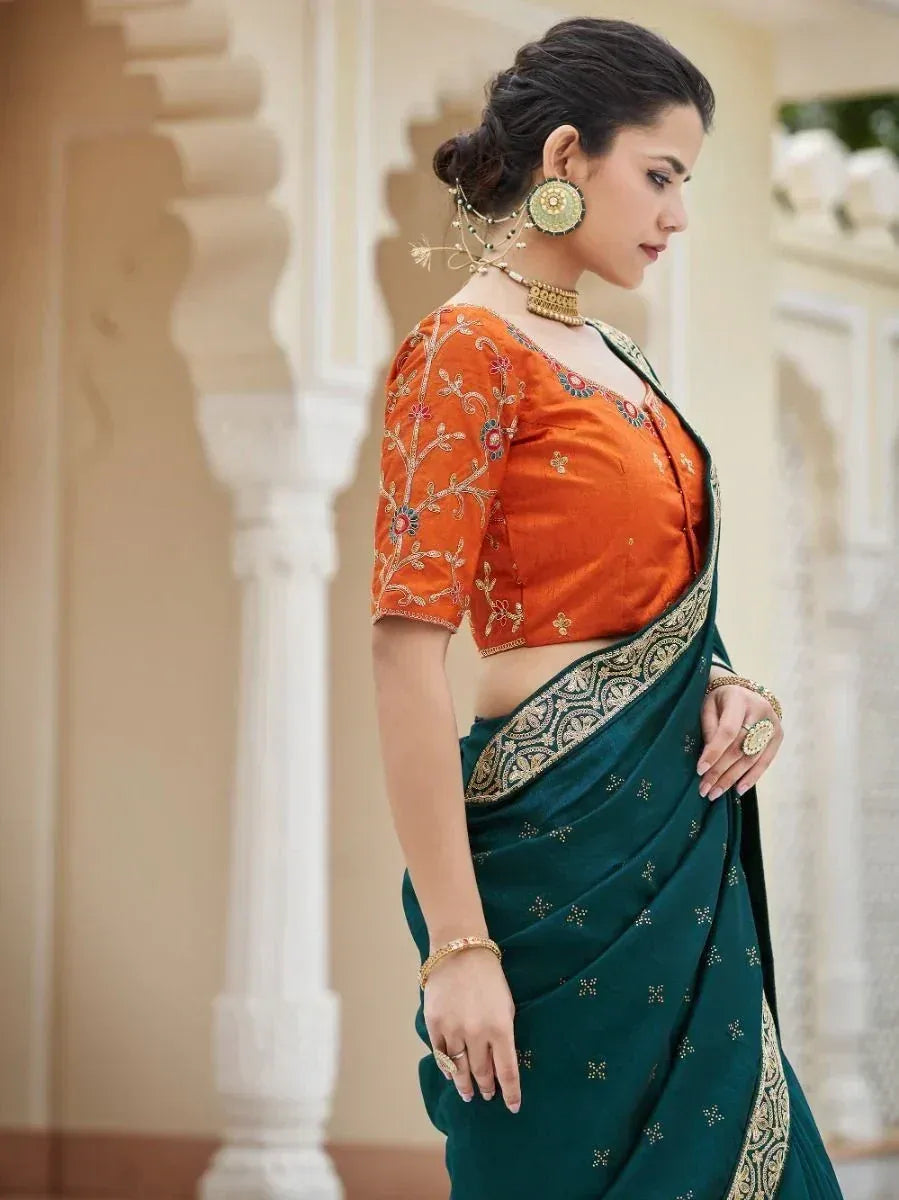 Woman in green saree with gold border and orange embroidered blouse, traditional Indian ethnic wear