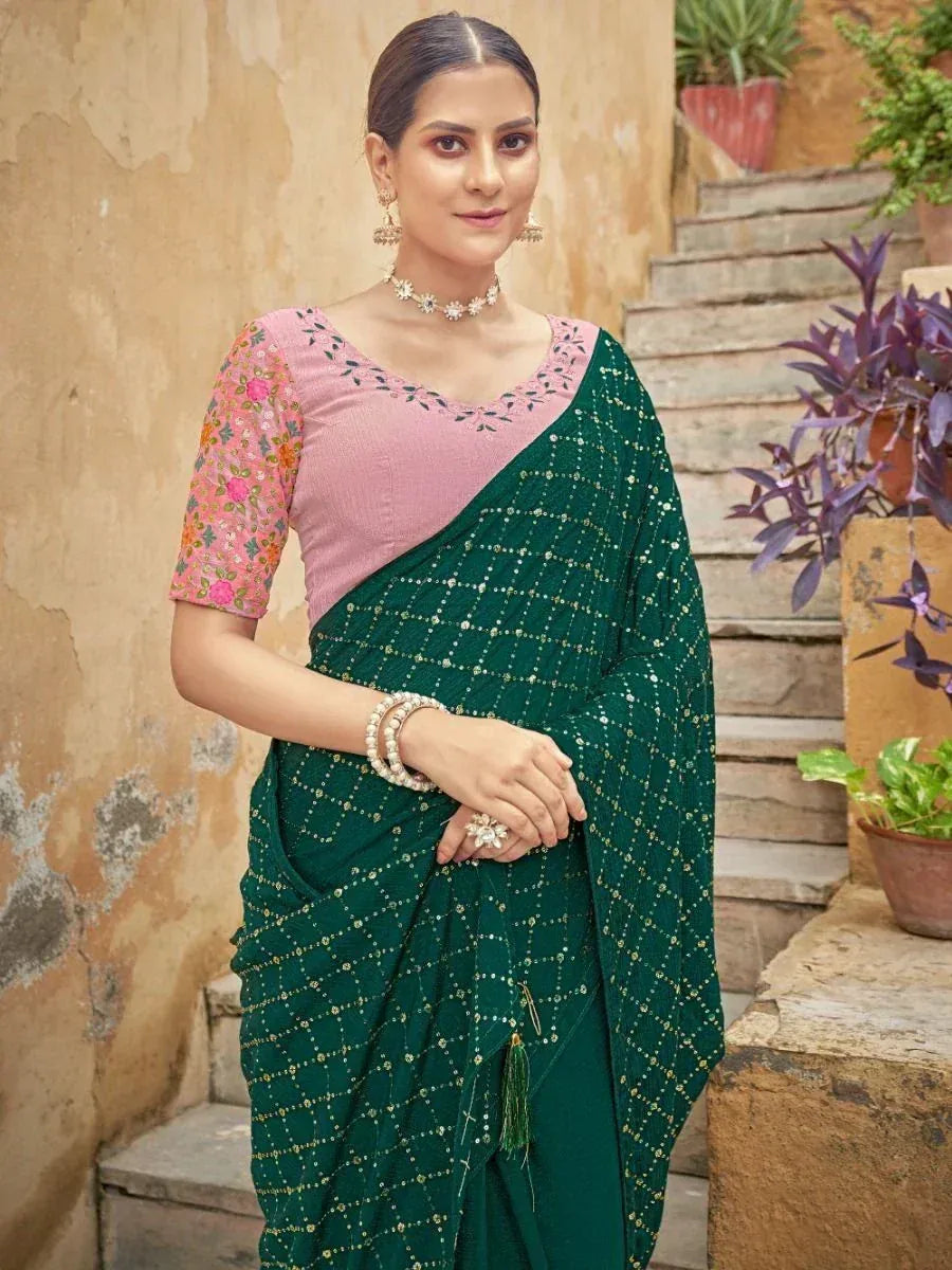 Emerald green designer saree with gold embroidery and pink floral blouse, perfect for Indian ethnic wear occasions.