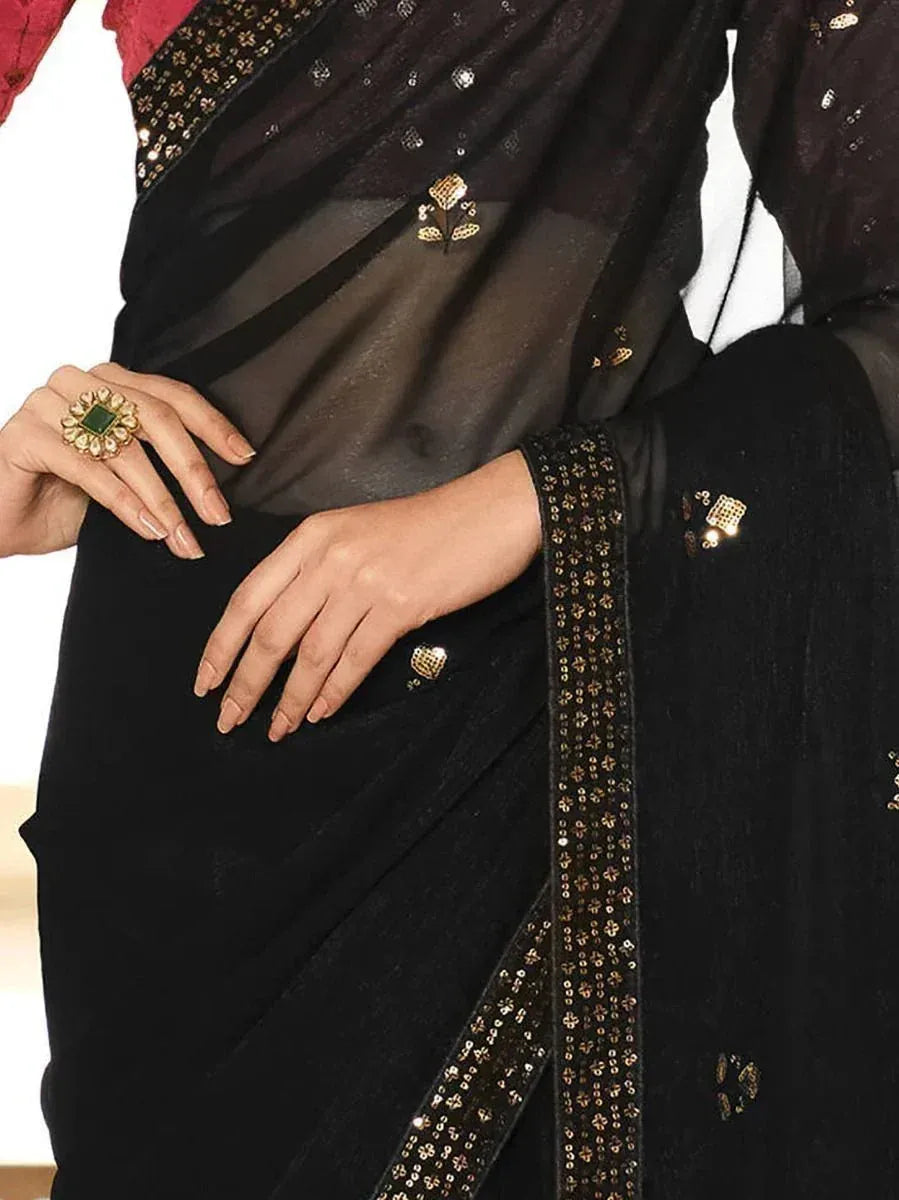 Black velvet saree with gold sequin border and floral embellishments, styled with statement ring