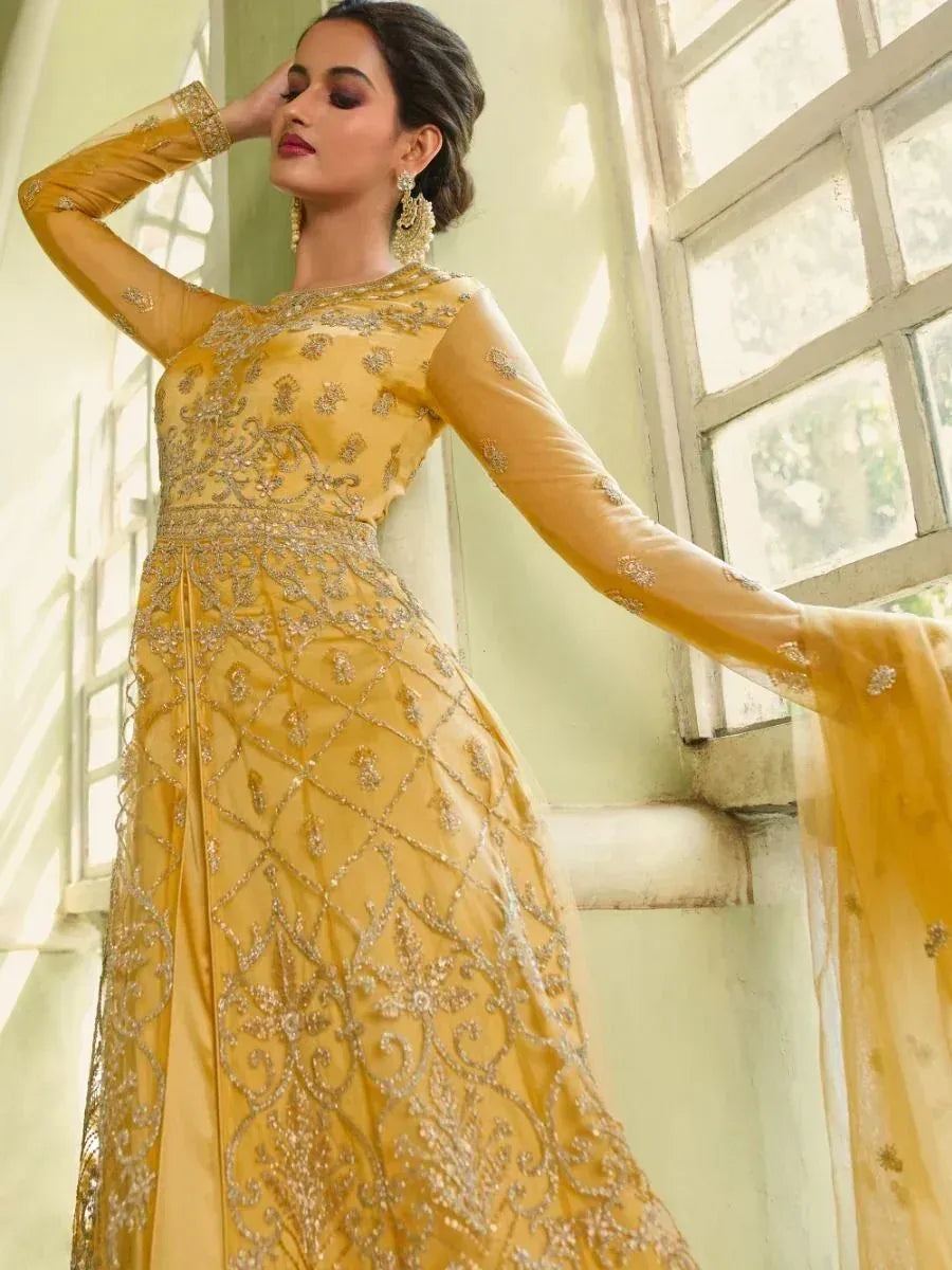 Elegant yellow ethnic gown with intricate gold embroidery, perfect for Indian weddings and festive occasions.