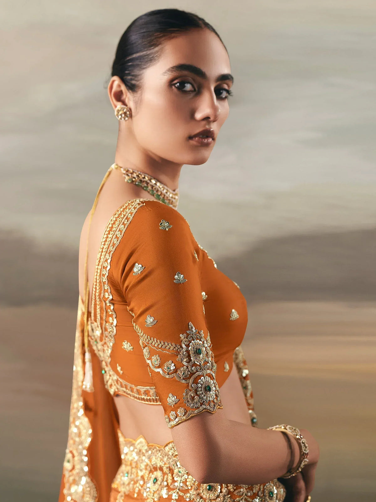 Elegant orange designer lehenga choli with gold embroidery and green accents