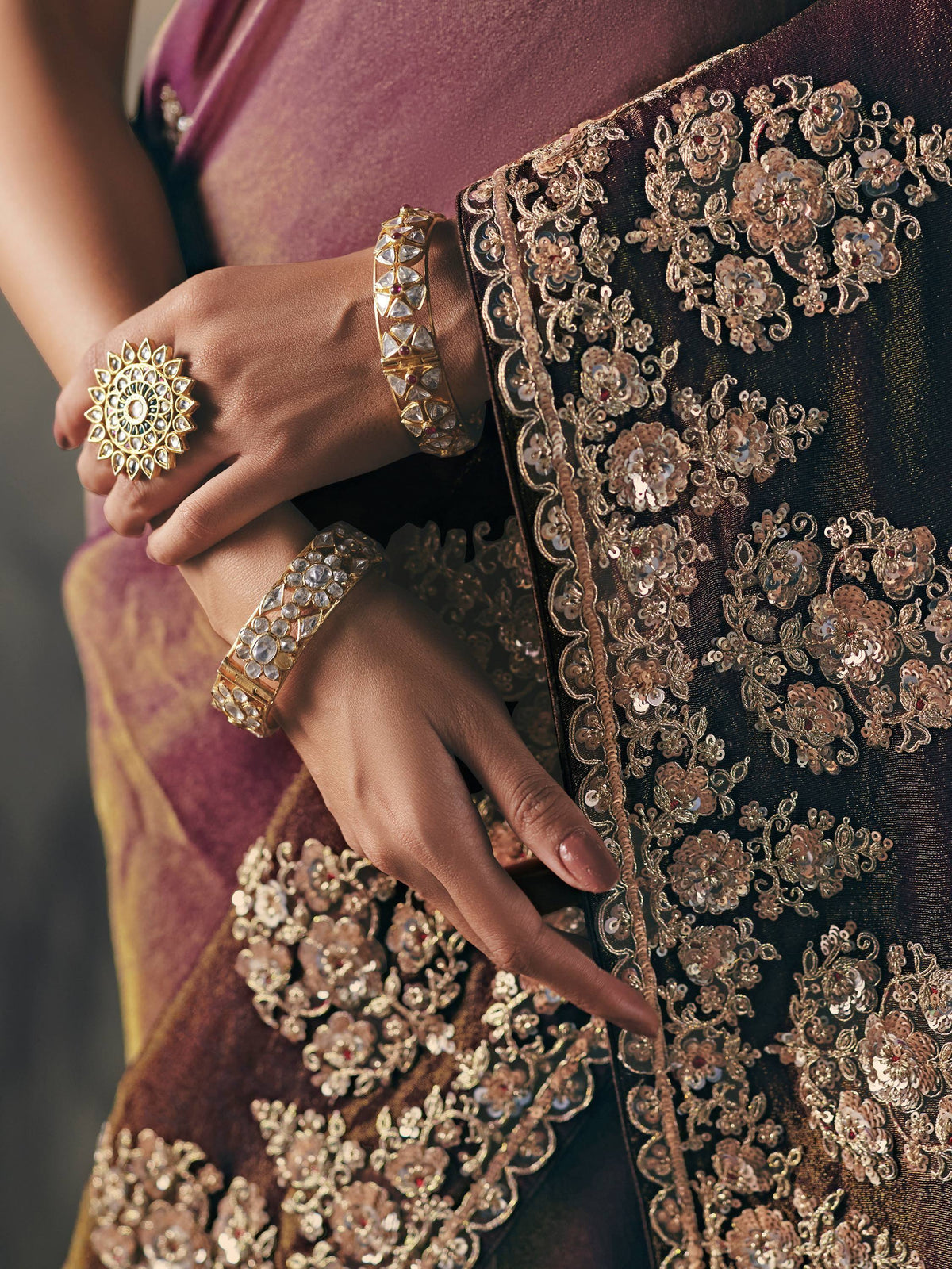 Elegant Indian ethnic wear with intricate gold embroidery, paired with traditional jewelry for festive occasions.