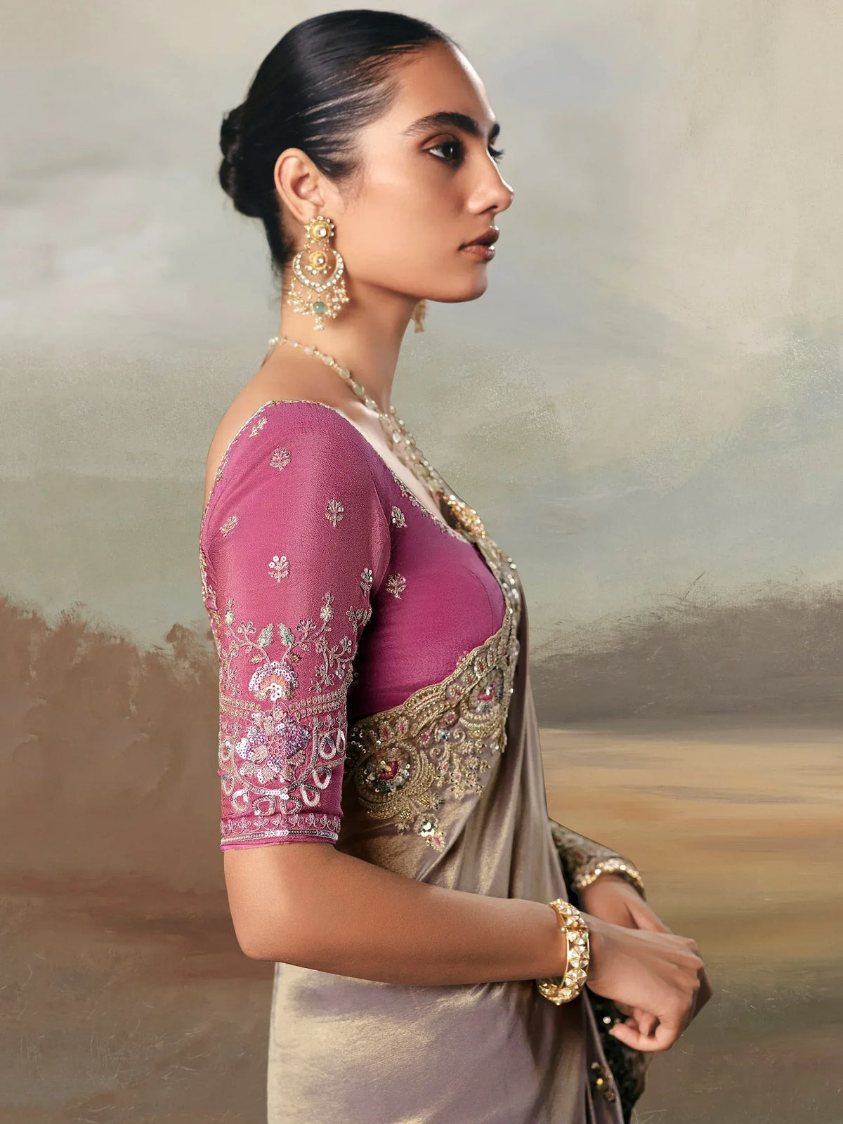 Elegant woman in purple embroidered blouse with gold embellished saree, traditional Indian ethnic wear