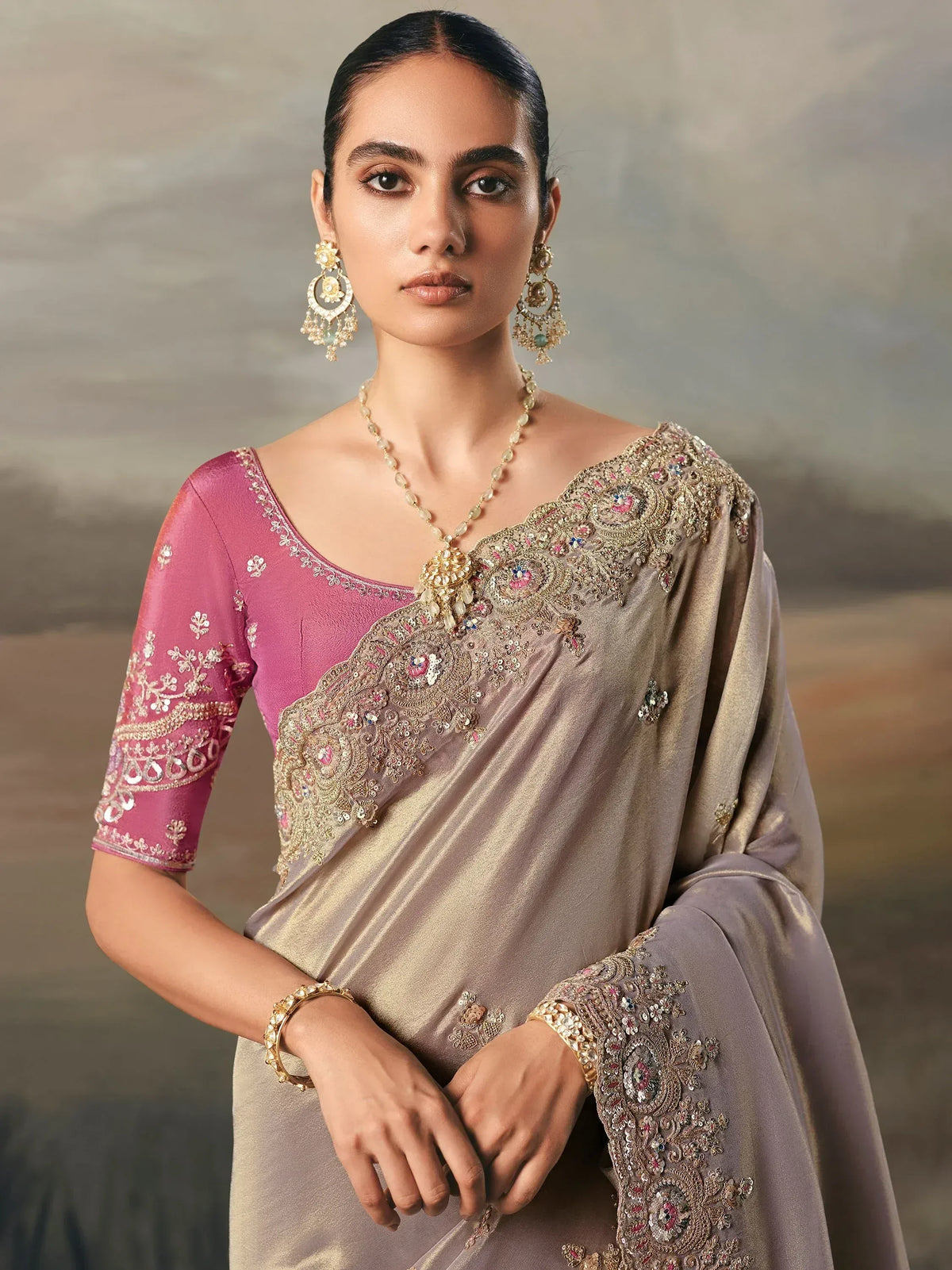 Elegant Indian saree with intricate gold embroidery, pink blouse, and traditional jewelry for festive occasions