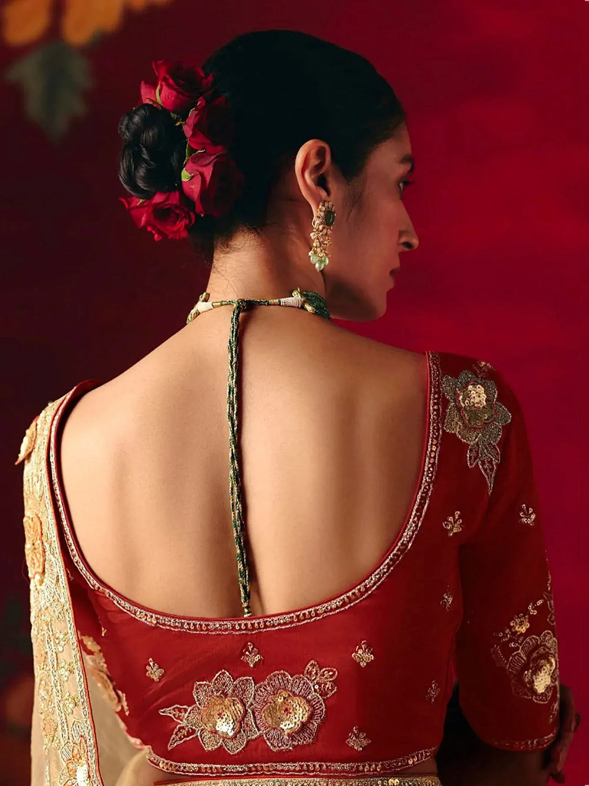 Red embroidered backless blouse with floral detailing, perfect for Indian ethnic wear and designer lehenga choli sets.