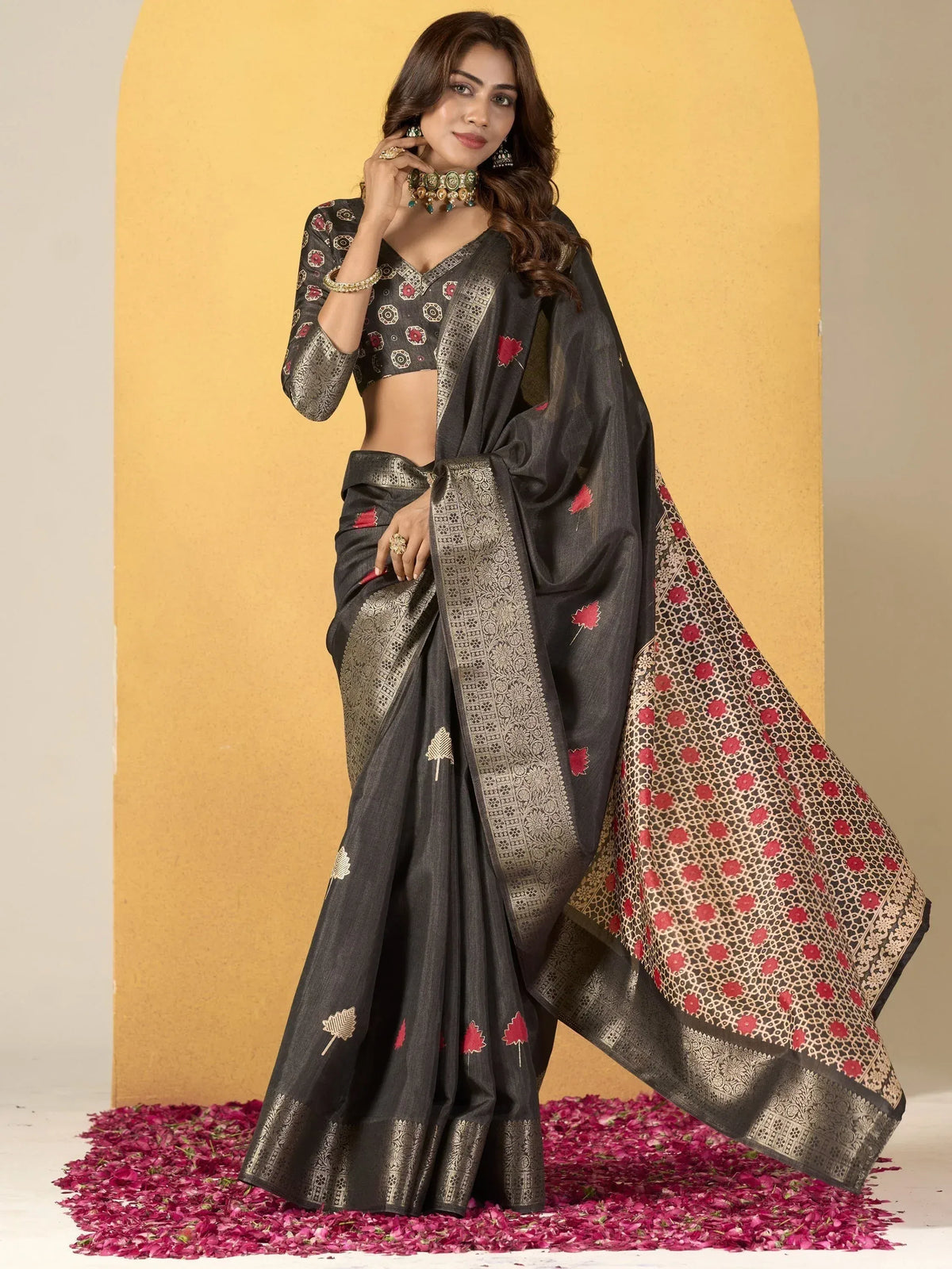 Elegant black saree with gold border and red floral motifs, paired with matching blouse for Indian ethnic wear