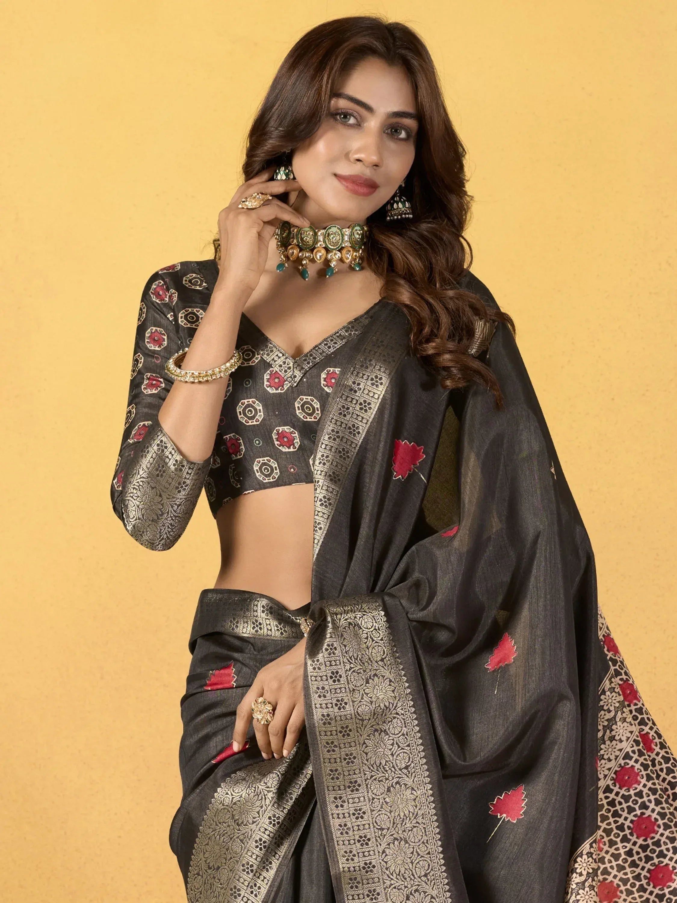 Elegant black saree with red floral embroidery and gold border, paired with matching blouse and traditional jewelry