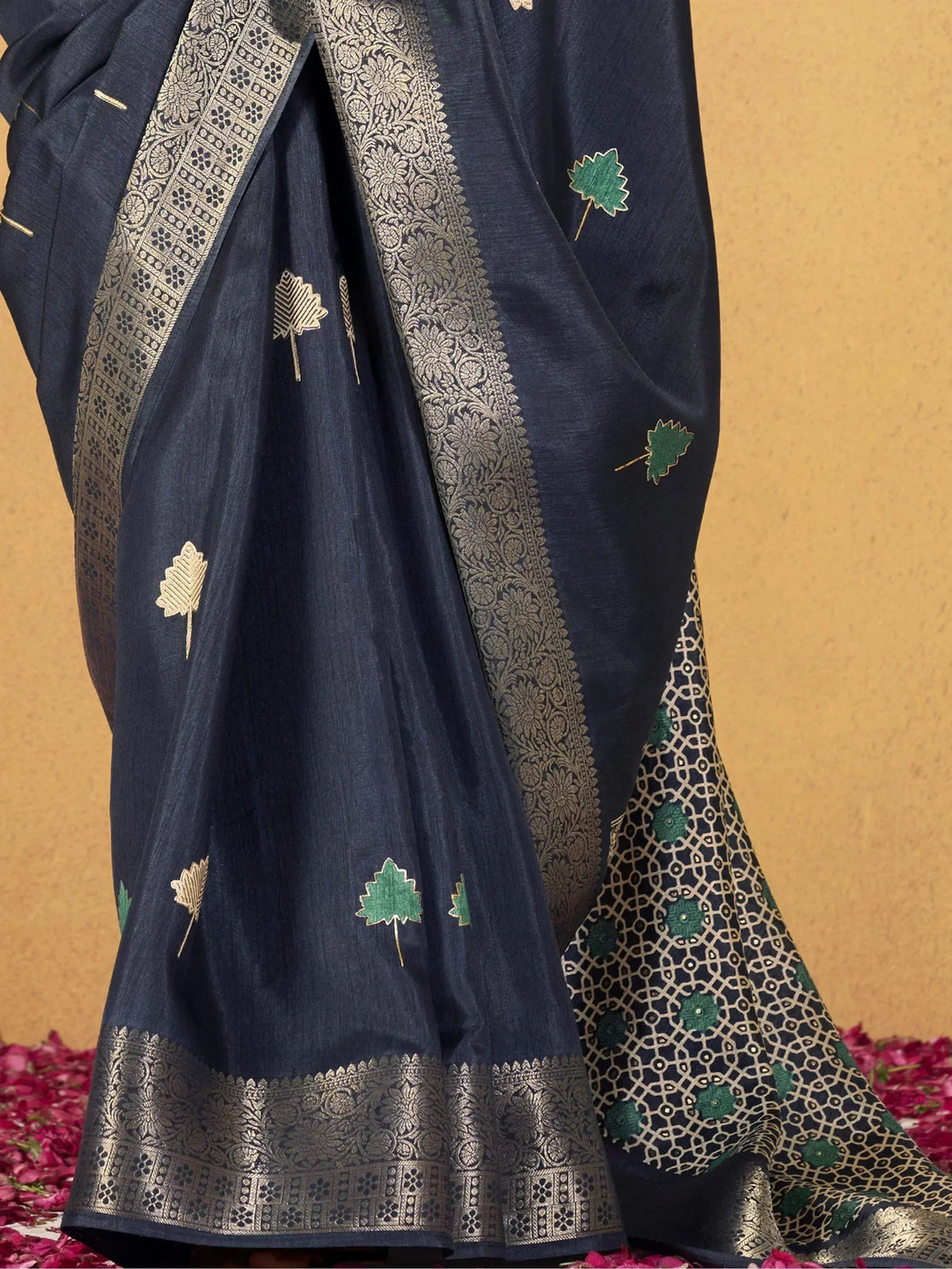 Navy blue ethnic saree with gold and green leaf embroidery, intricate border, perfect for festive occasions.
