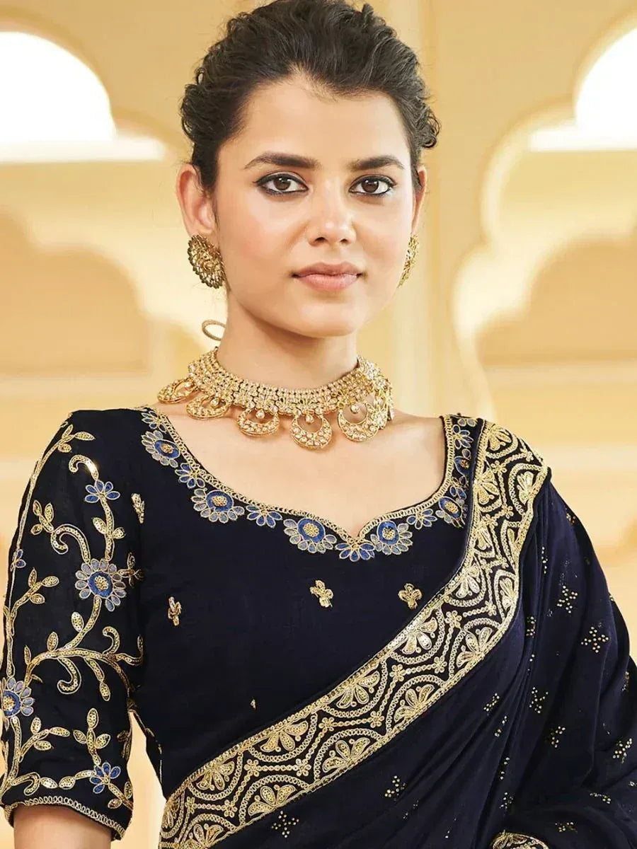 Elegant navy blue saree with gold and blue floral embroidery, paired with traditional jewelry