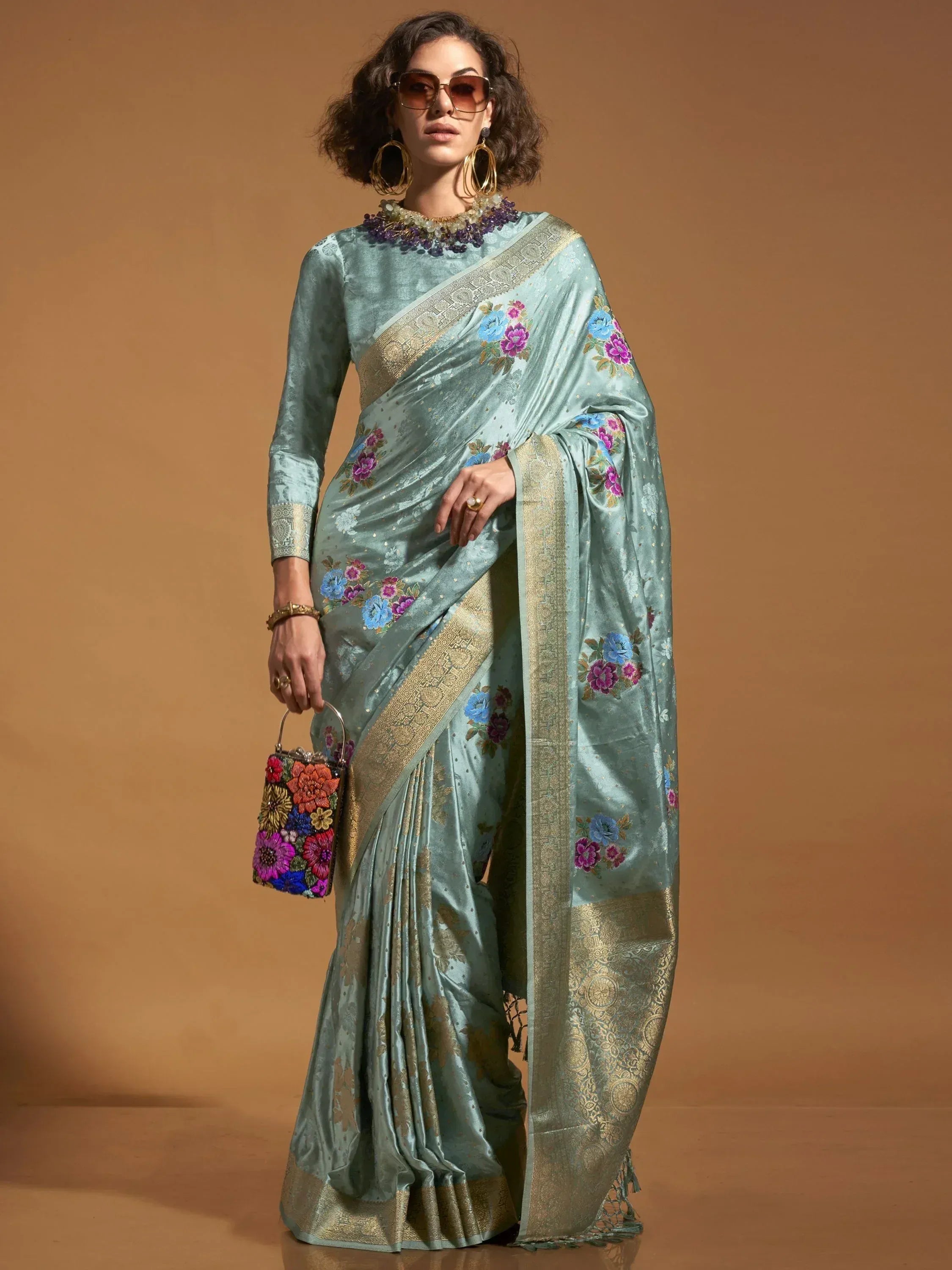 Elegant light blue floral saree with gold border, perfect for Indian ethnic wear occasions