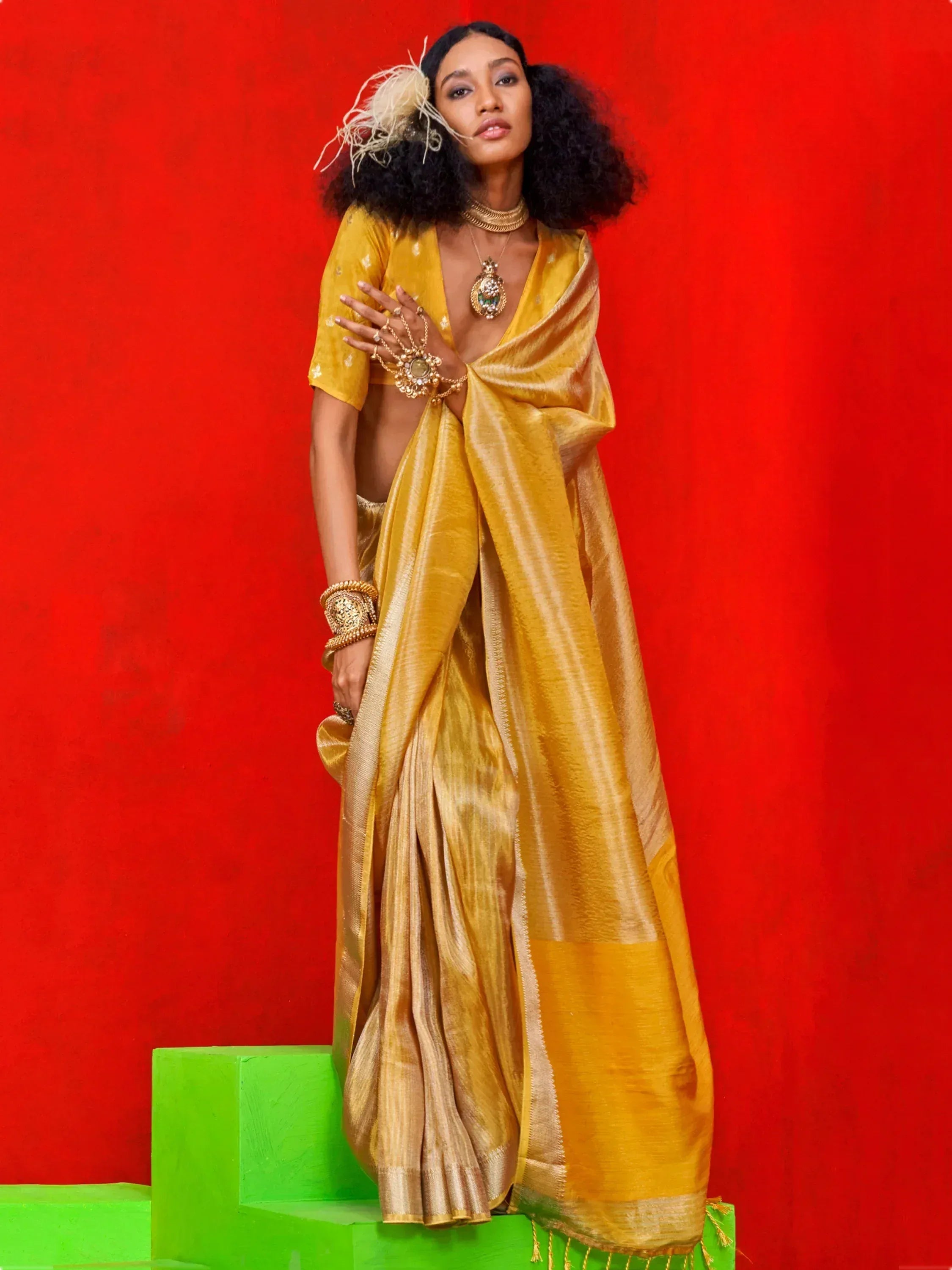 Woman in mustard yellow silk saree with gold jewelry, styled for Indian ethnic wear