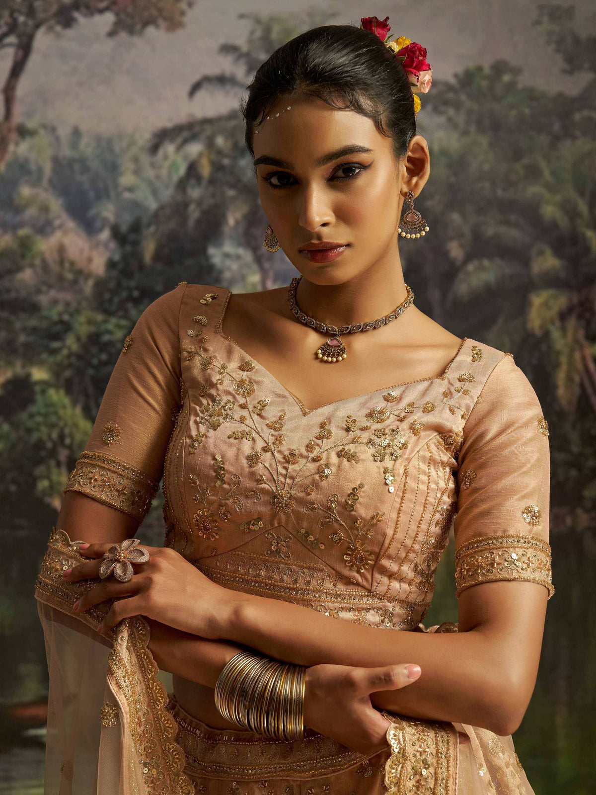 Elegant Indian ethnic wear with gold embroidery, floral hair accessories, and traditional jewelry for festive occasions.