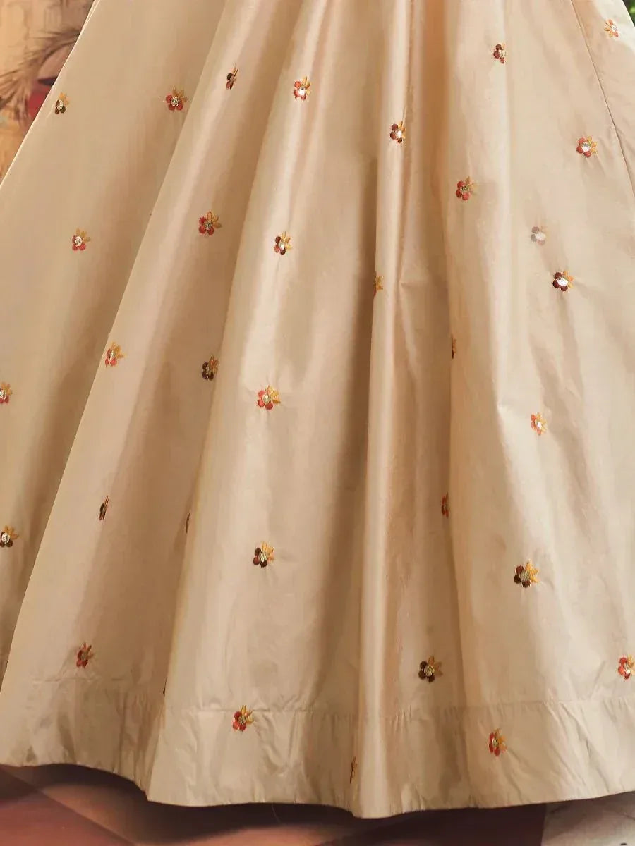 Cream ethnic gown with floral embroidery and sequins, perfect for Indian occasions
