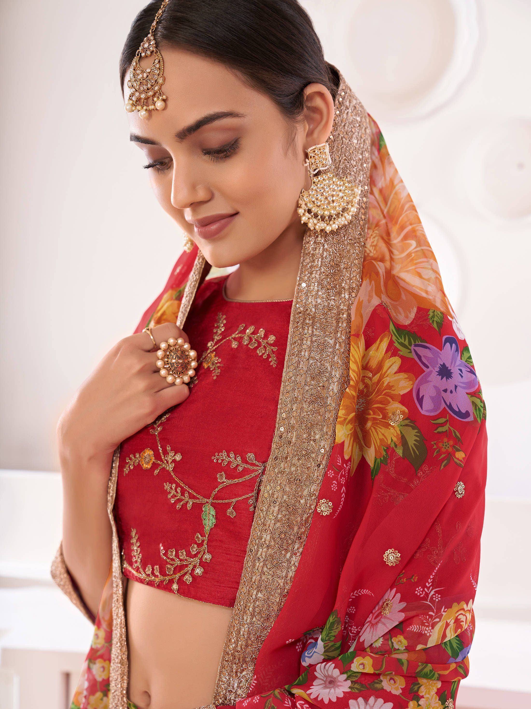 Red floral lehenga choli with gold embroidery, matching dupatta, and traditional Indian jewelry