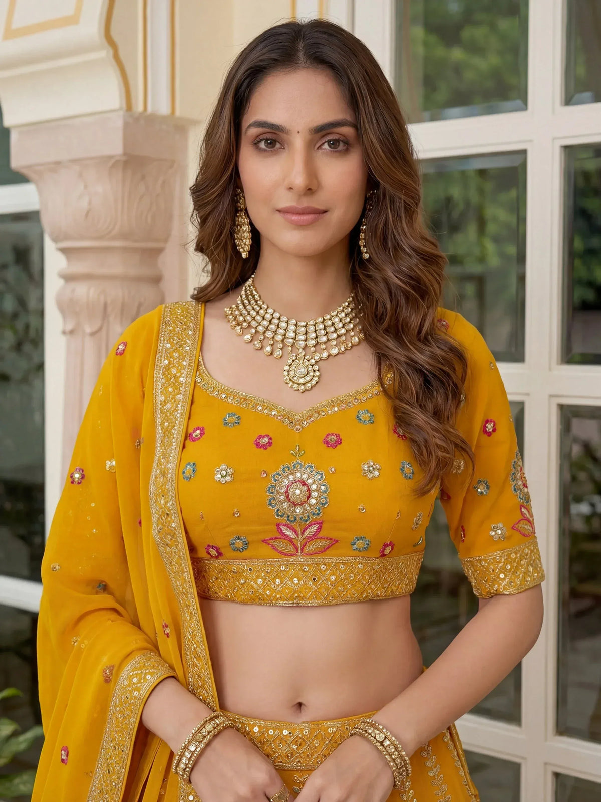 Yellow floral embroidered lehenga choli with gold jewelry, perfect for Indian ethnic wear