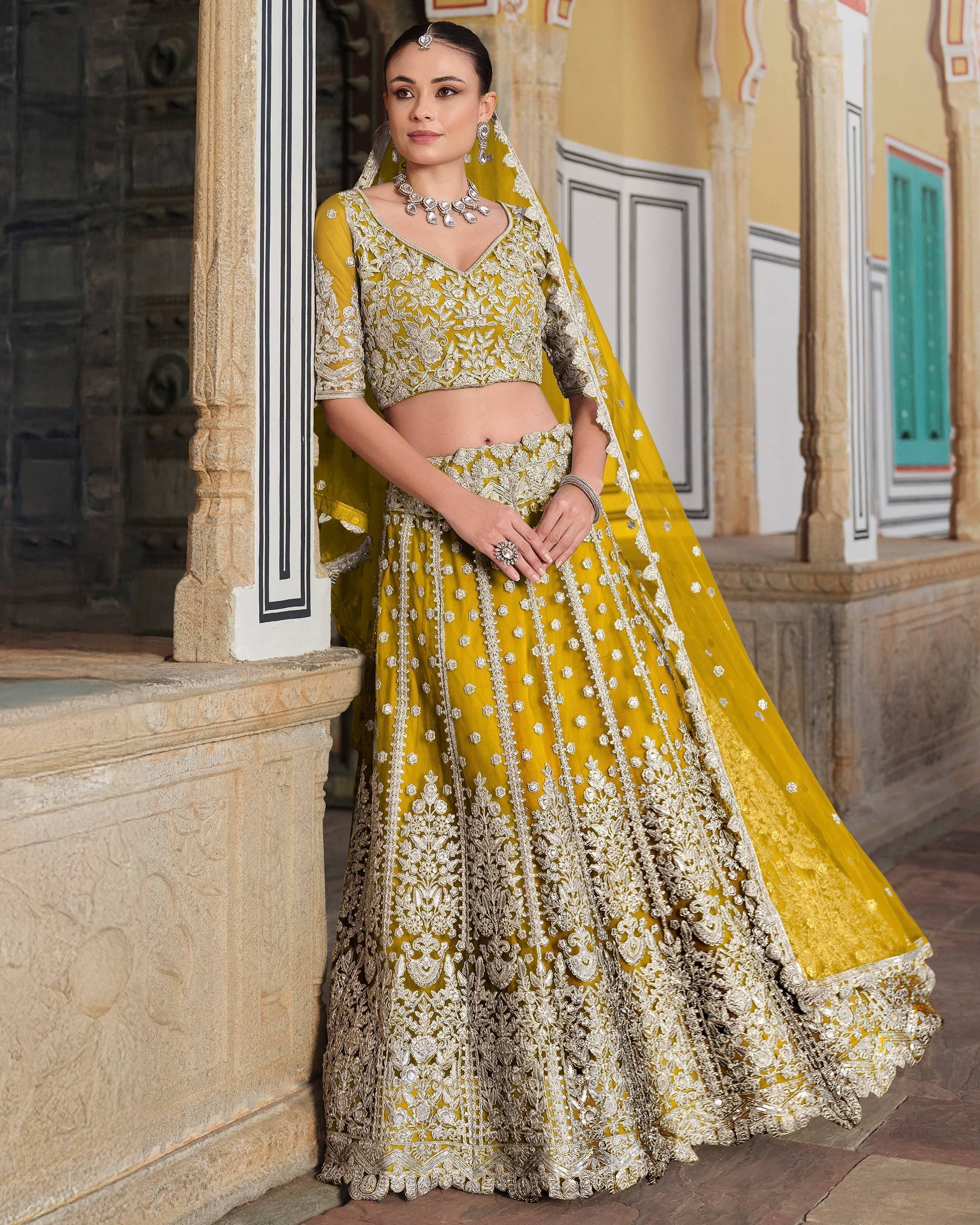 Yellow designer lehenga choli with heavy silver embroidery, perfect for Indian weddings and ethnic events.