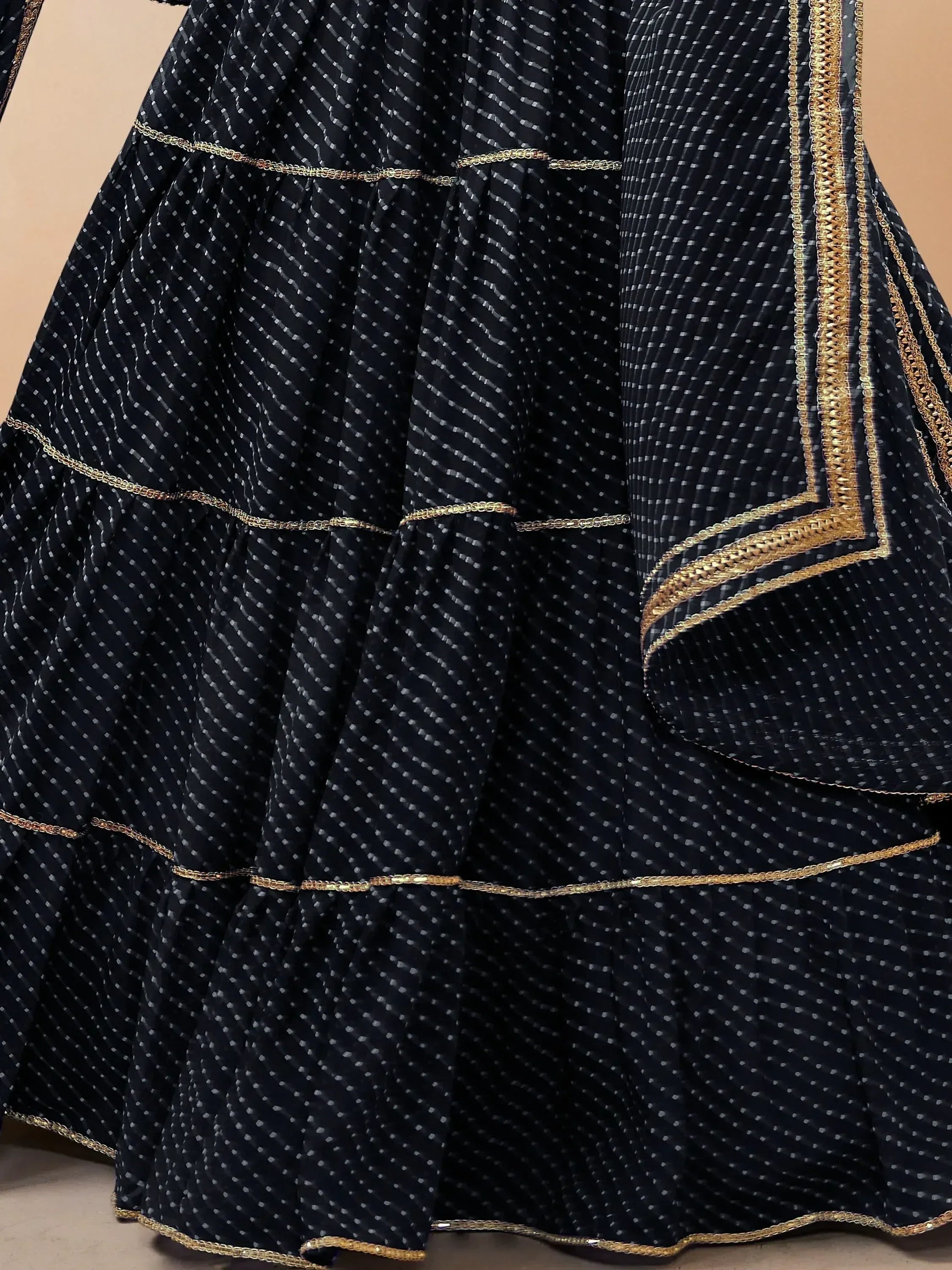 Black ethnic gown with gold trim and pleated design, perfect for Indian festive wear