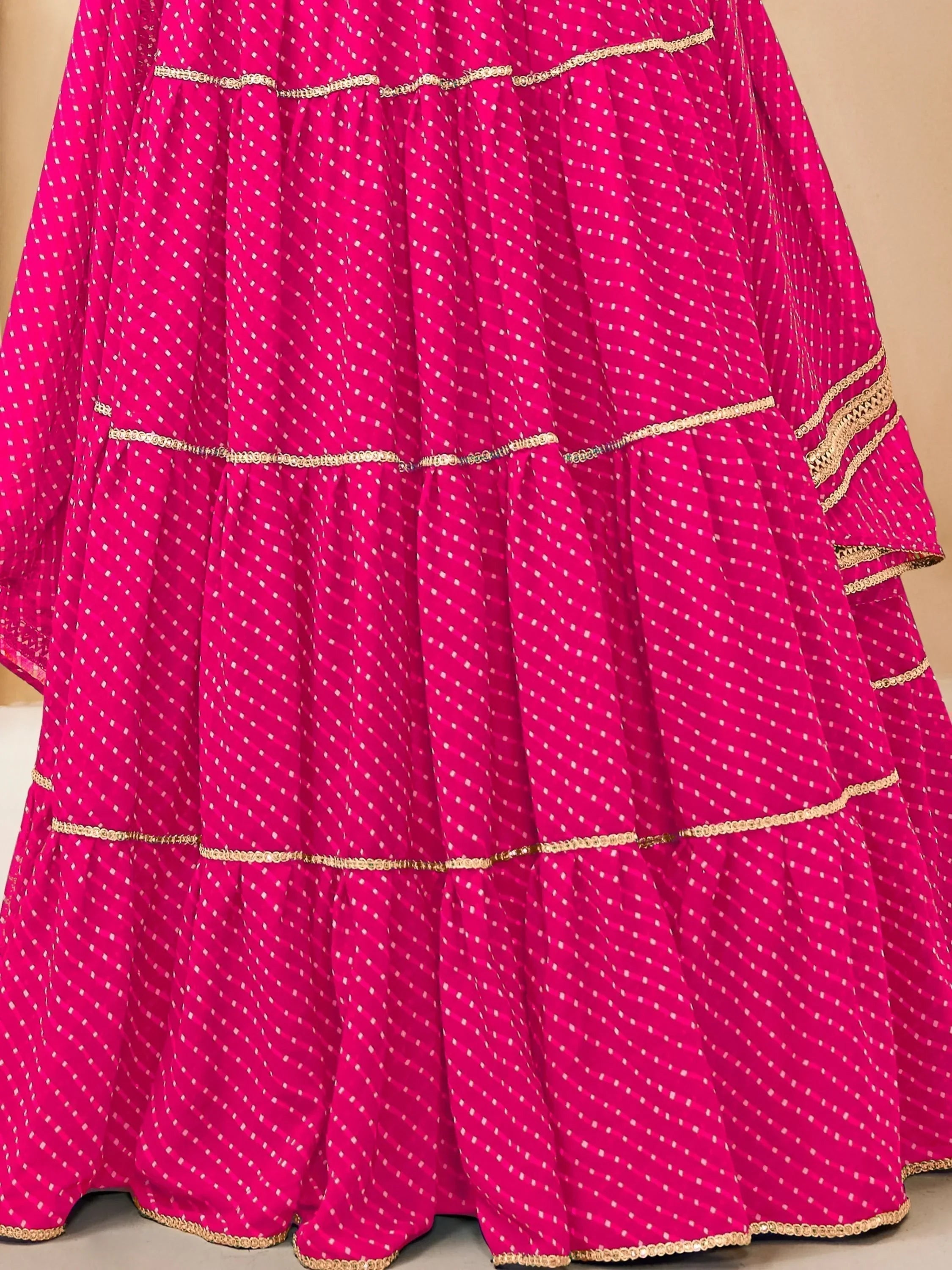 Fuchsia pink tiered lehenga with white polka dots and gold trim, Indian ethnic wear