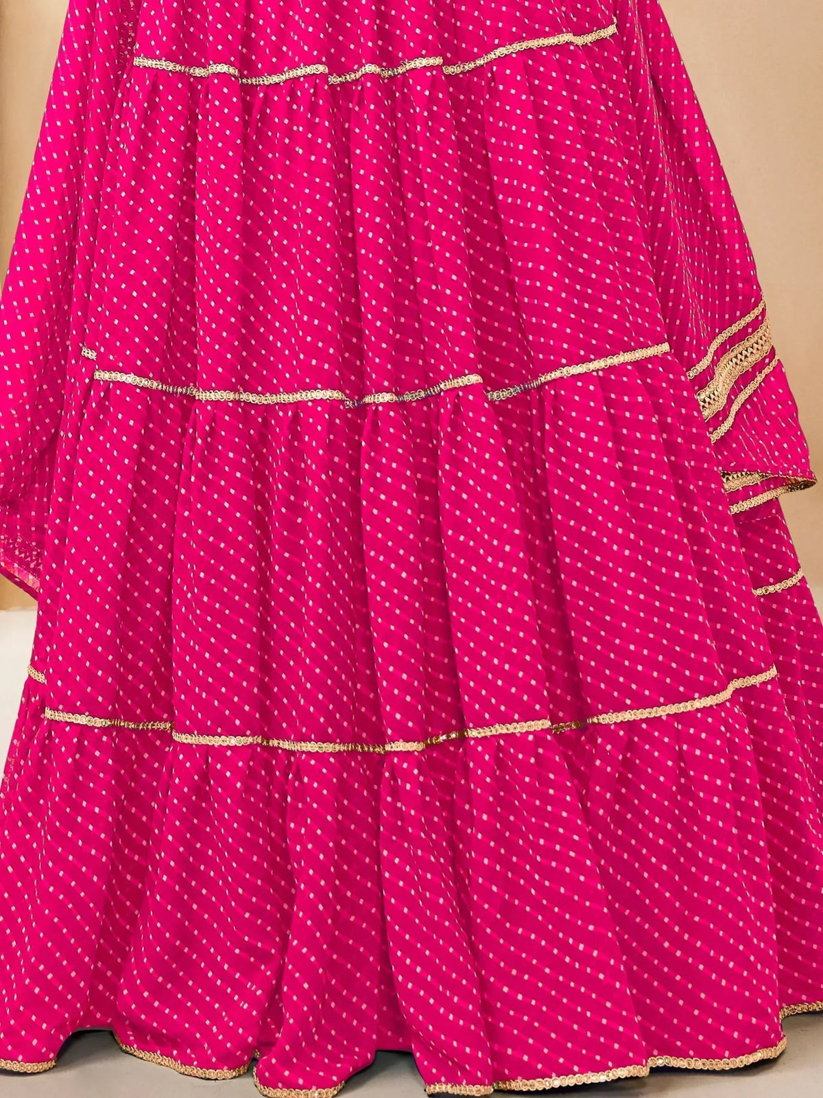 Fuchsia pink tiered lehenga with white polka dots and gold trim, Indian ethnic wear