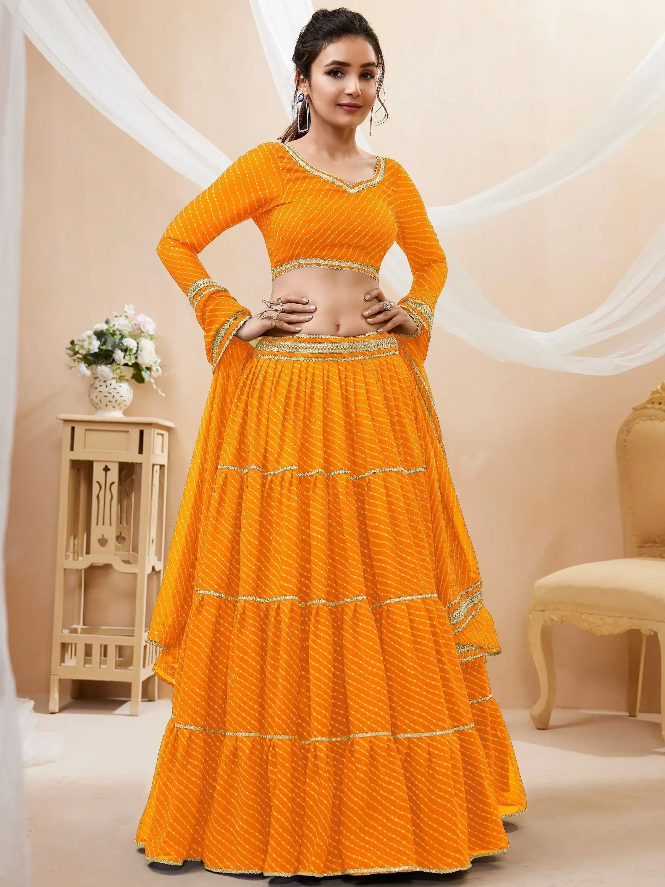 Vibrant orange lehenga choli with gold embroidery, perfect for Indian ethnic wear and festive occasions.