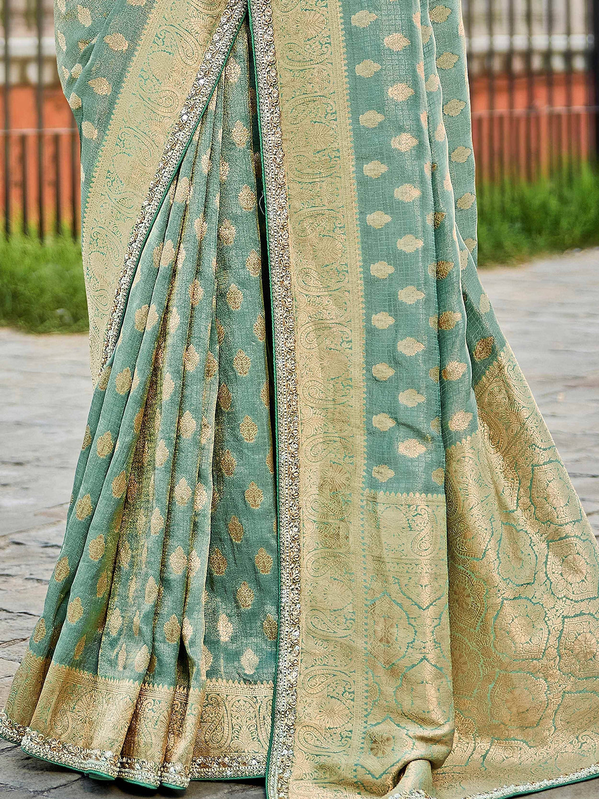 Mint green saree with gold paisley and floral motifs, intricate border, perfect for ethnic occasions