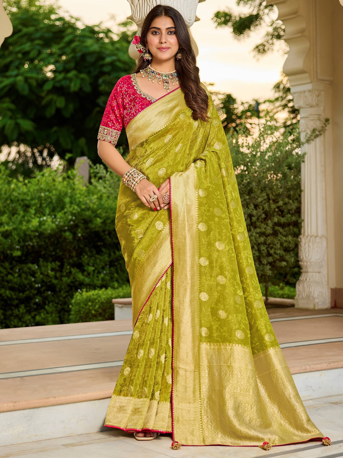 Elegant lime green silk saree with gold floral motifs and pink border, paired with embroidered blouse for Indian ethnic wear