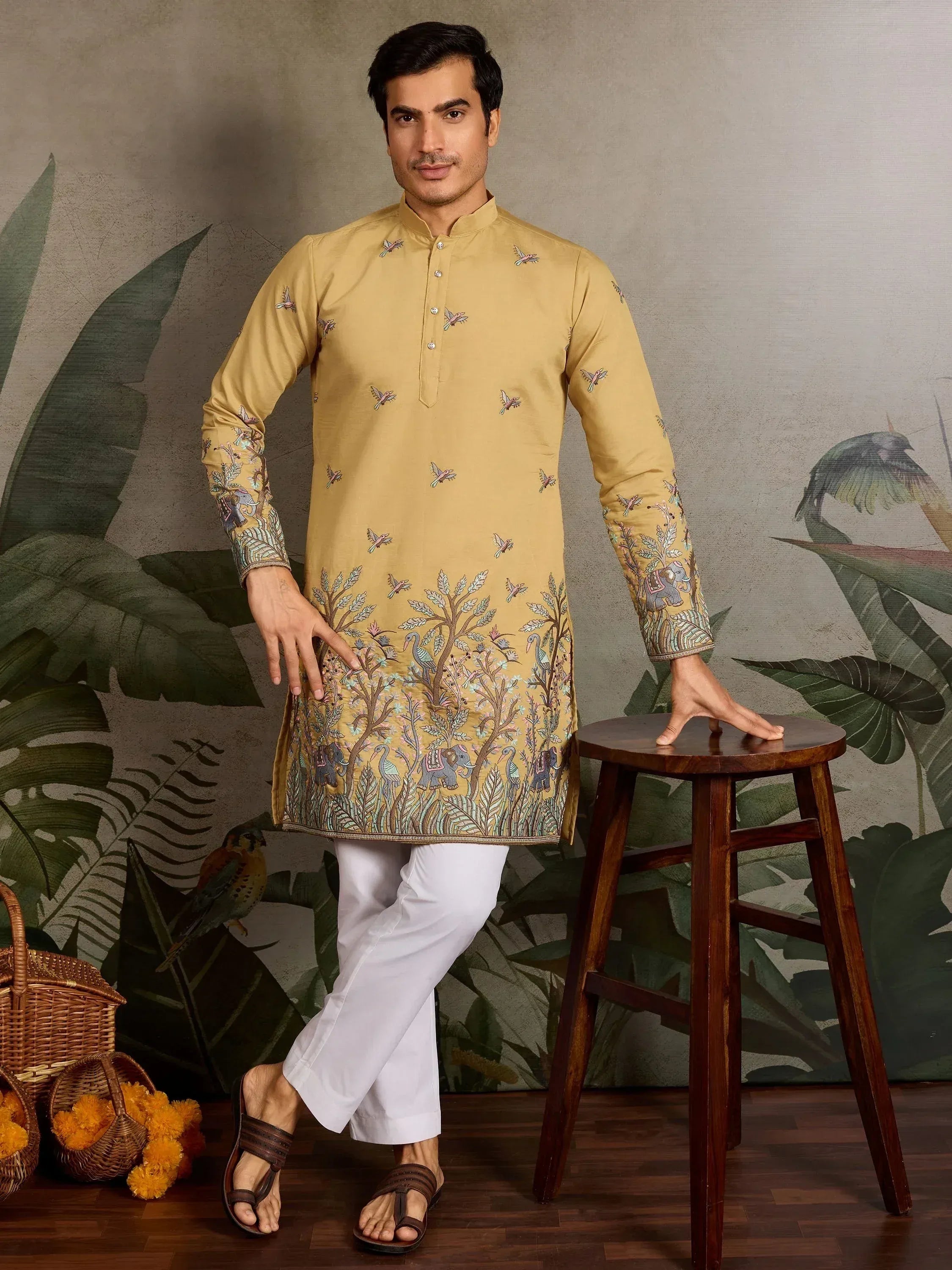 Men's mustard yellow kurta with bird and elephant embroidery, paired with white pants for ethnic wear