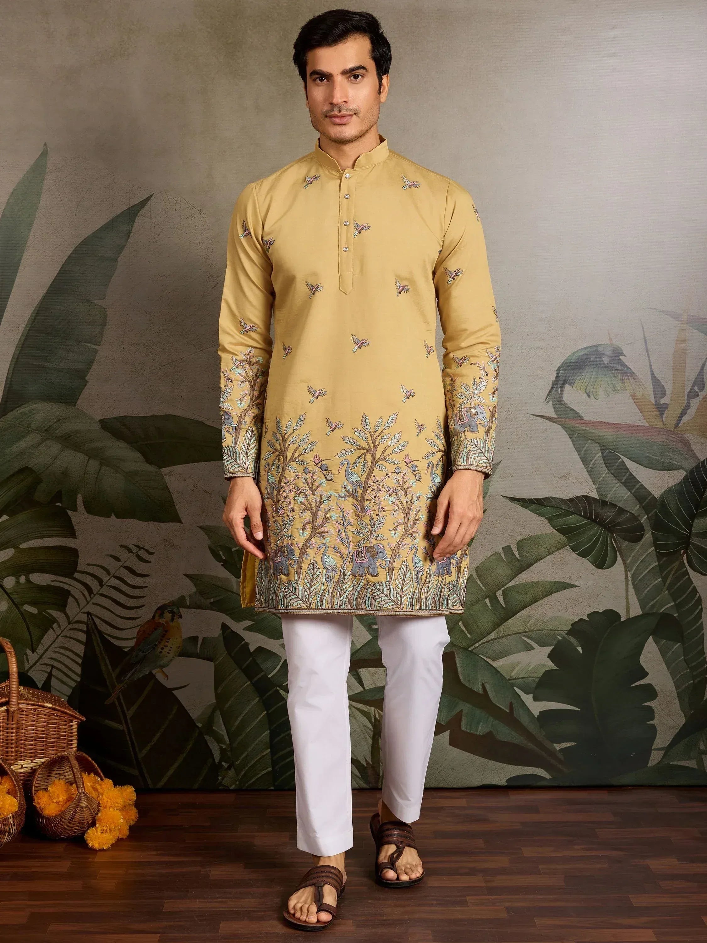 Men's mustard yellow kurta with bird and elephant embroidery, paired with white pants for ethnic wear