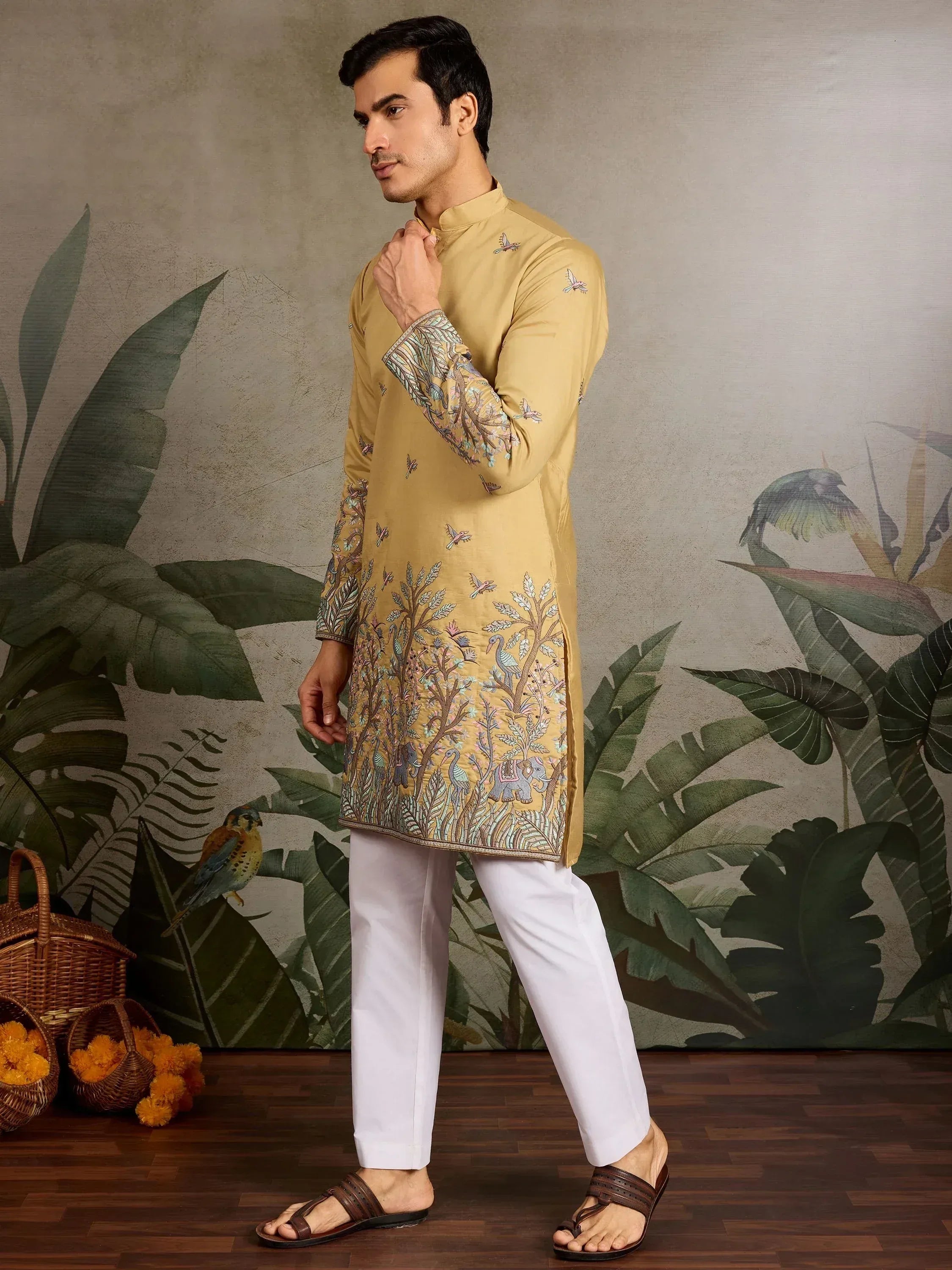 Men's mustard kurta with bird and elephant embroidery, paired with white pants for ethnic wear