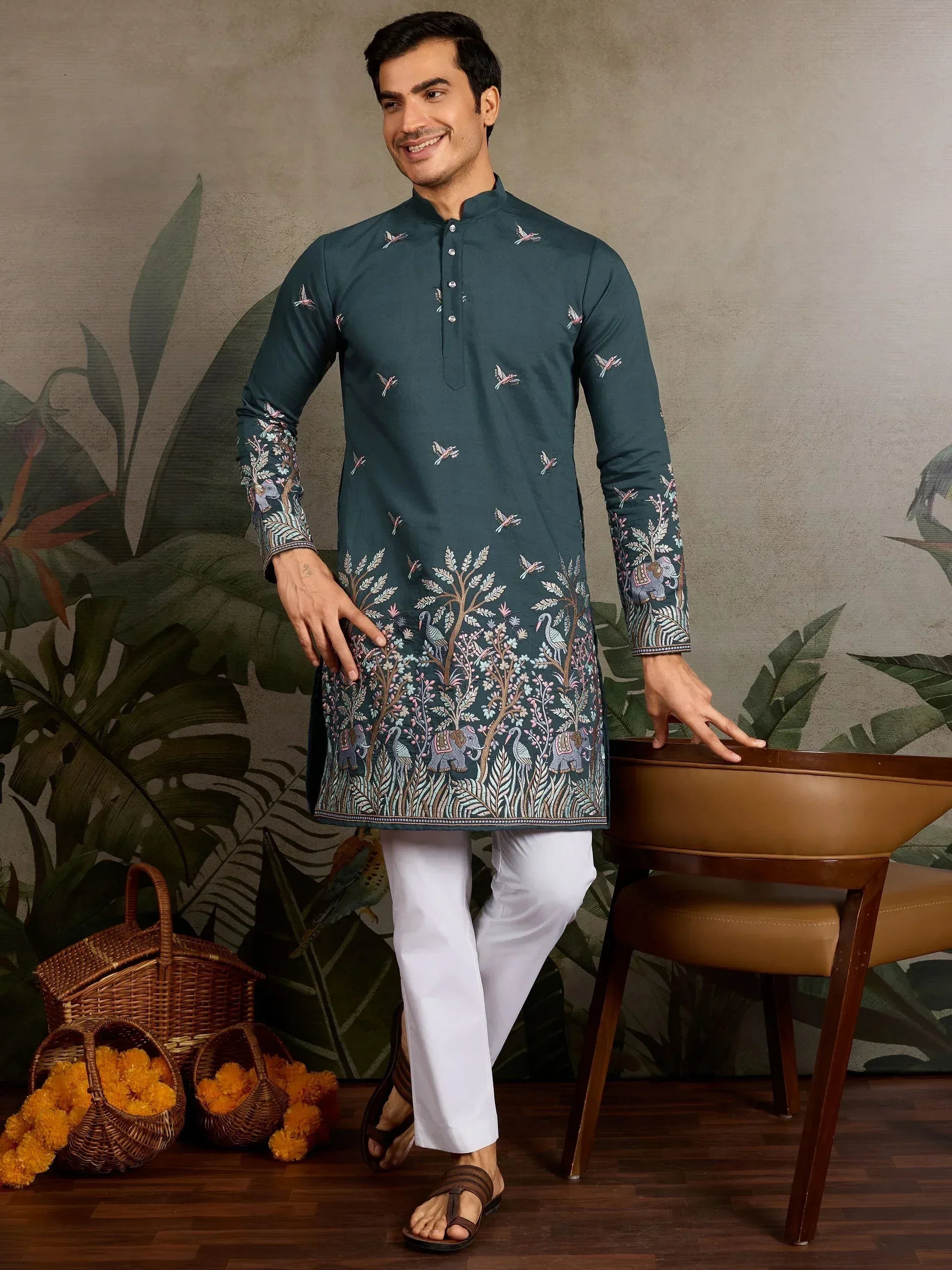 Men's teal embroidered kurta with elephant and bird motifs, paired with white pants for ethnic wear