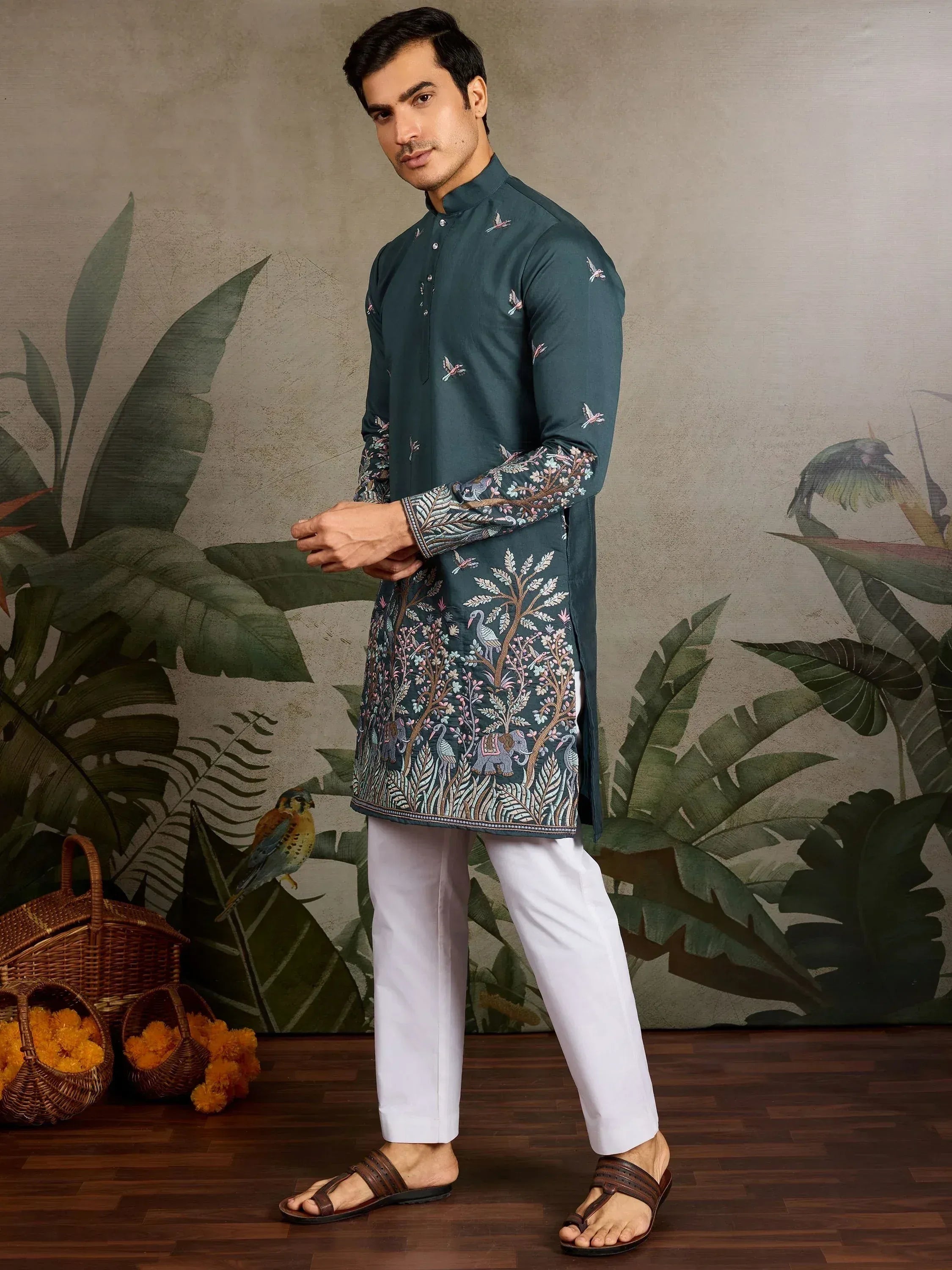 Men's embroidered kurta with bird and tree motifs, paired with white pants for ethnic wear