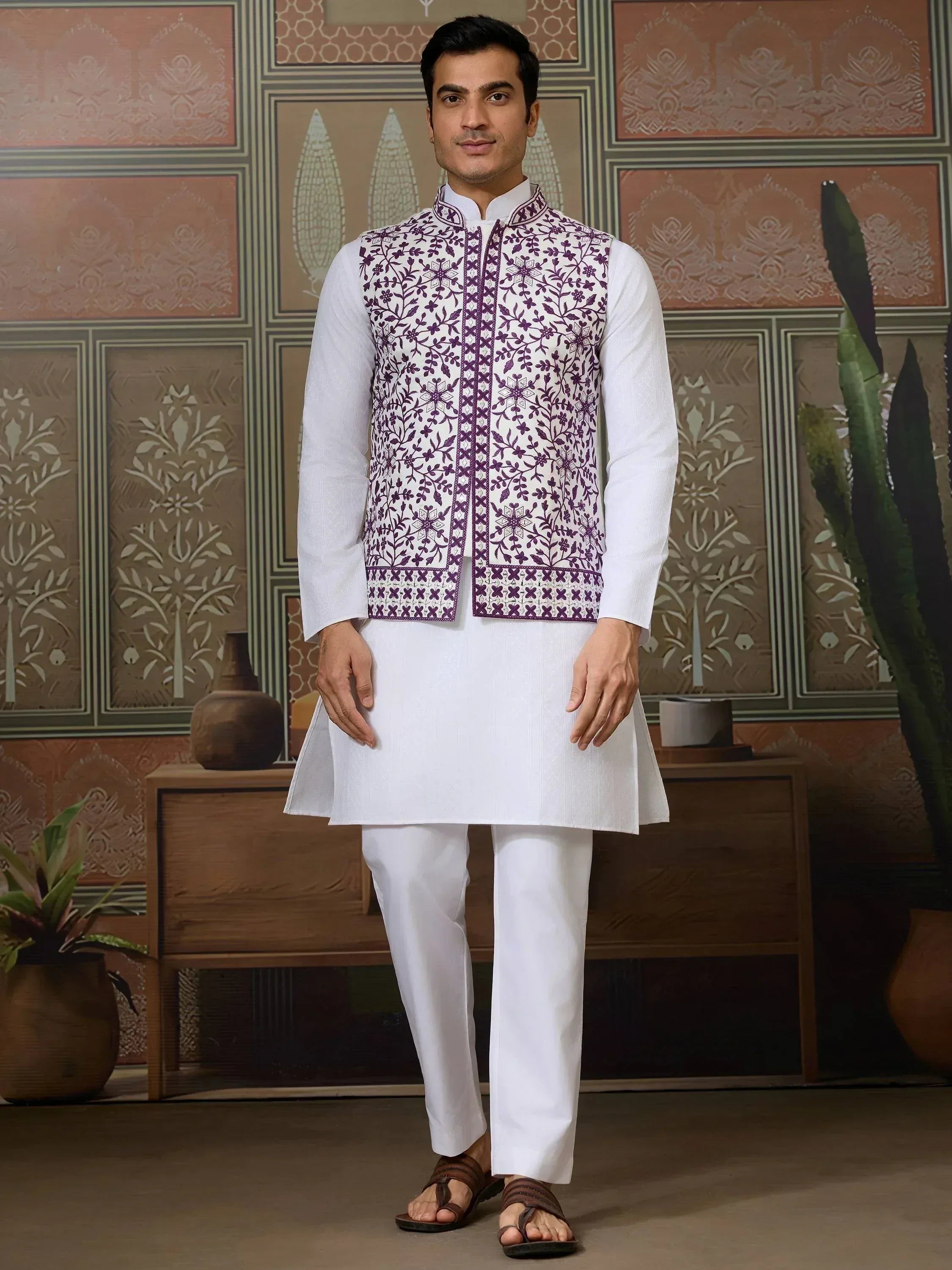 Man in white kurta pajama with purple floral embroidered vest, traditional Indian ethnic wear