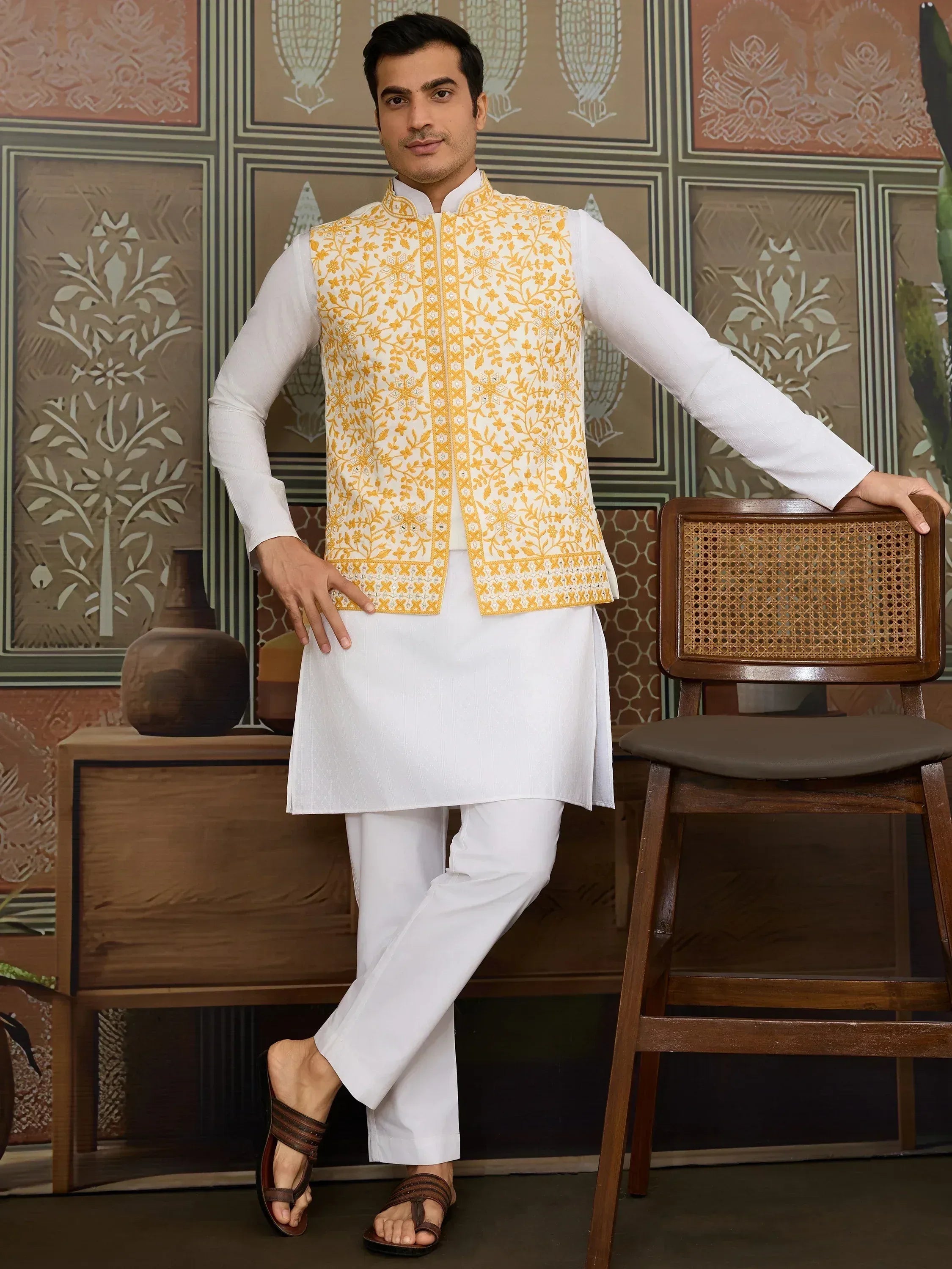 Man in white kurta pajama with yellow floral embroidered Nehru jacket, ethnic Indian wear