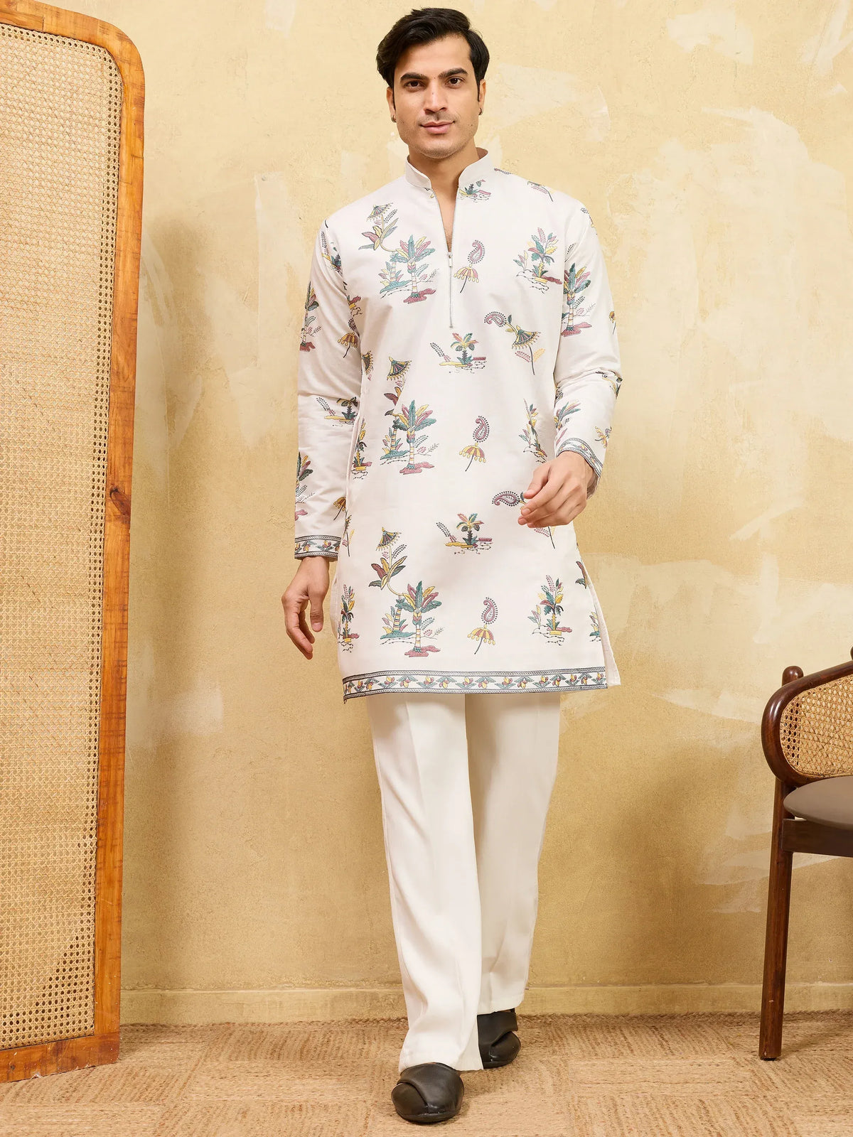 Man wearing a white floral printed ethnic kurta and matching trousers.