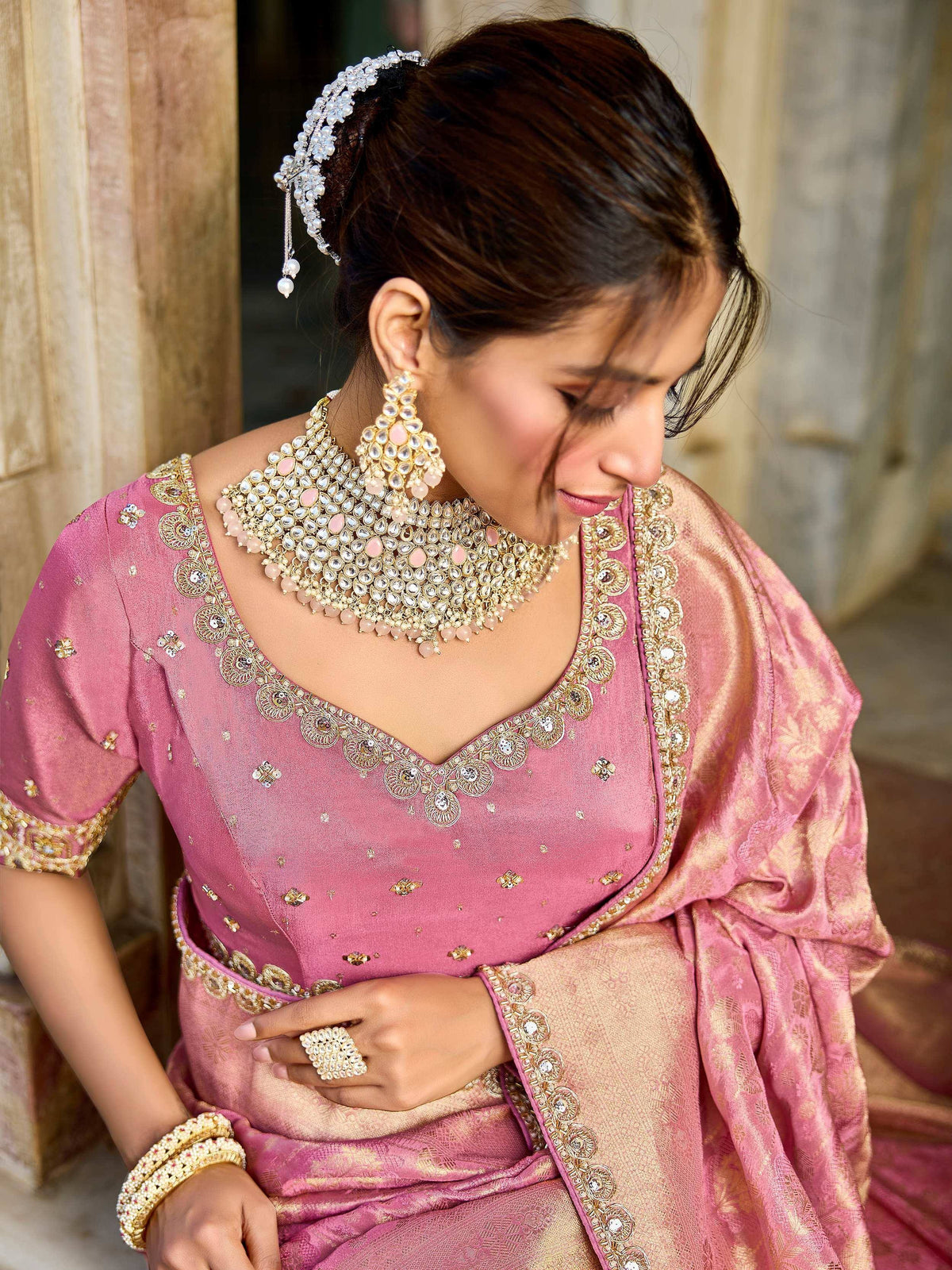 Elegant pink designer lehenga choli with gold embroidery and traditional jewelry