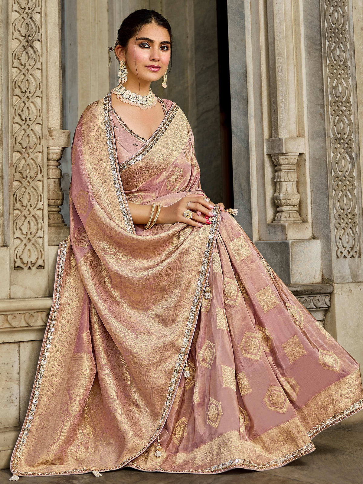 Elegant pink and gold designer lehenga choli with intricate embroidery, perfect for Indian weddings and festive occasions.