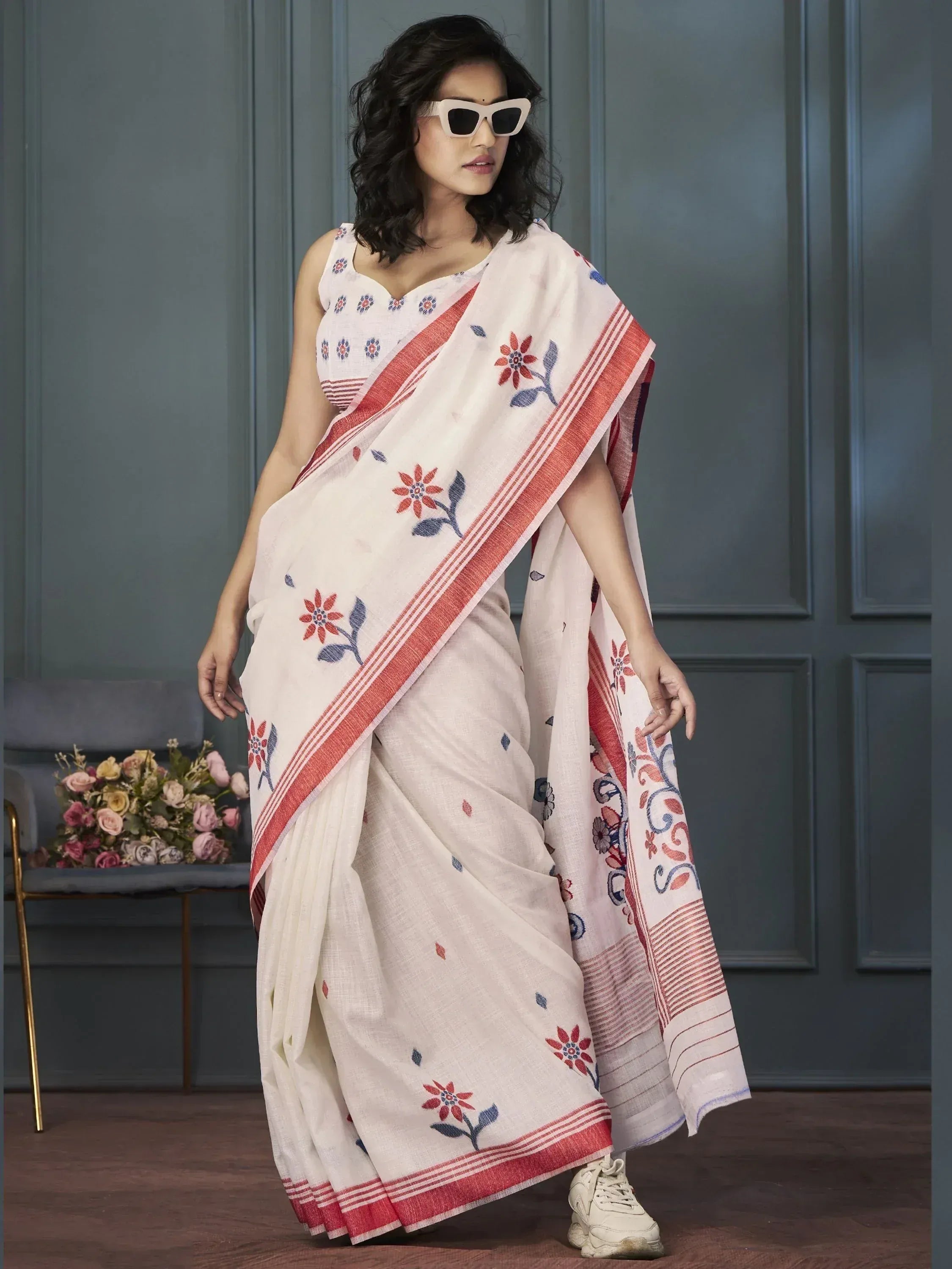 White floral embroidered saree with red border, styled with sunglasses and sneakers for modern ethnic look