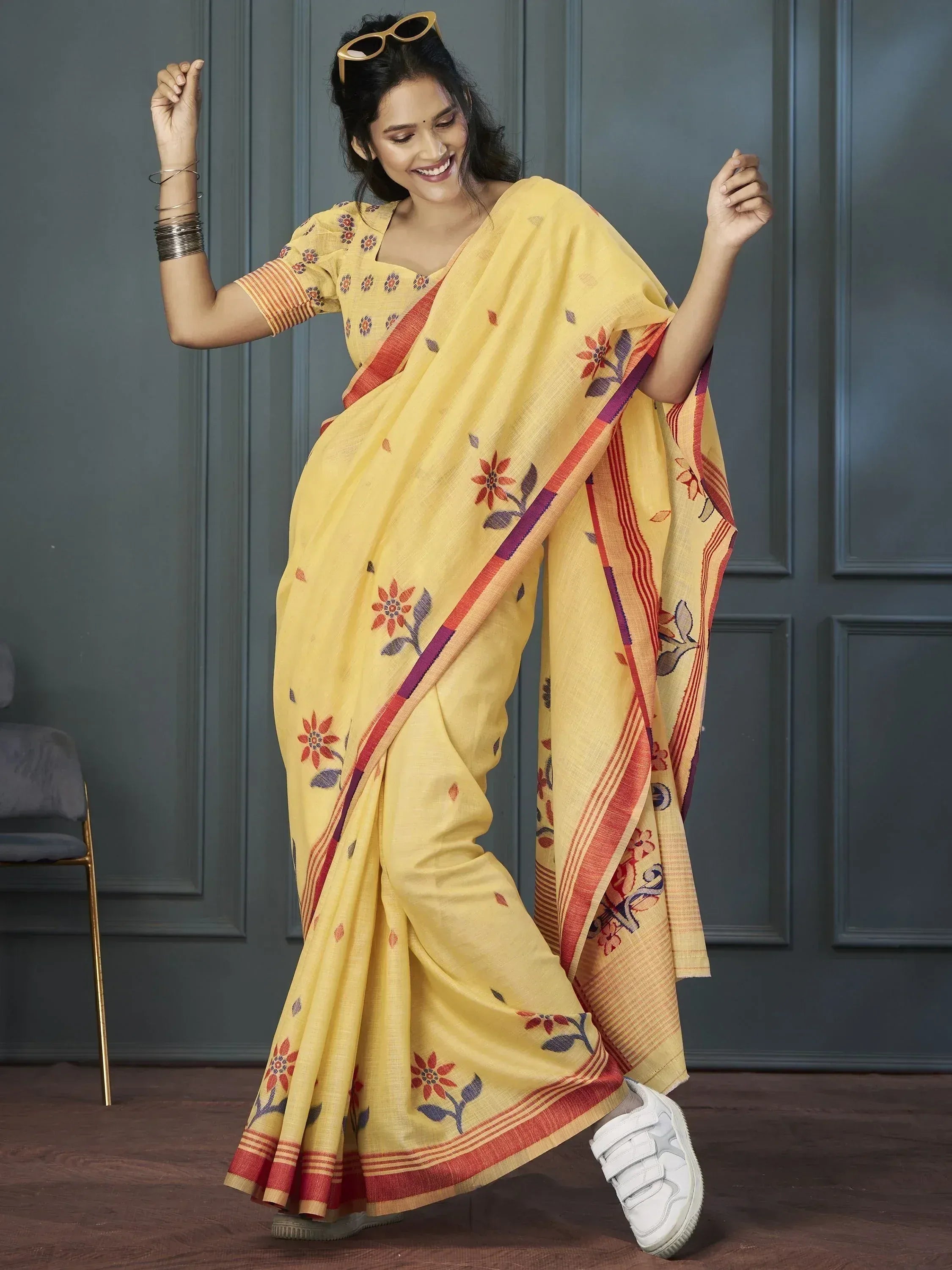 Yellow floral printed saree with red border, paired with white sneakers for casual ethnic wear