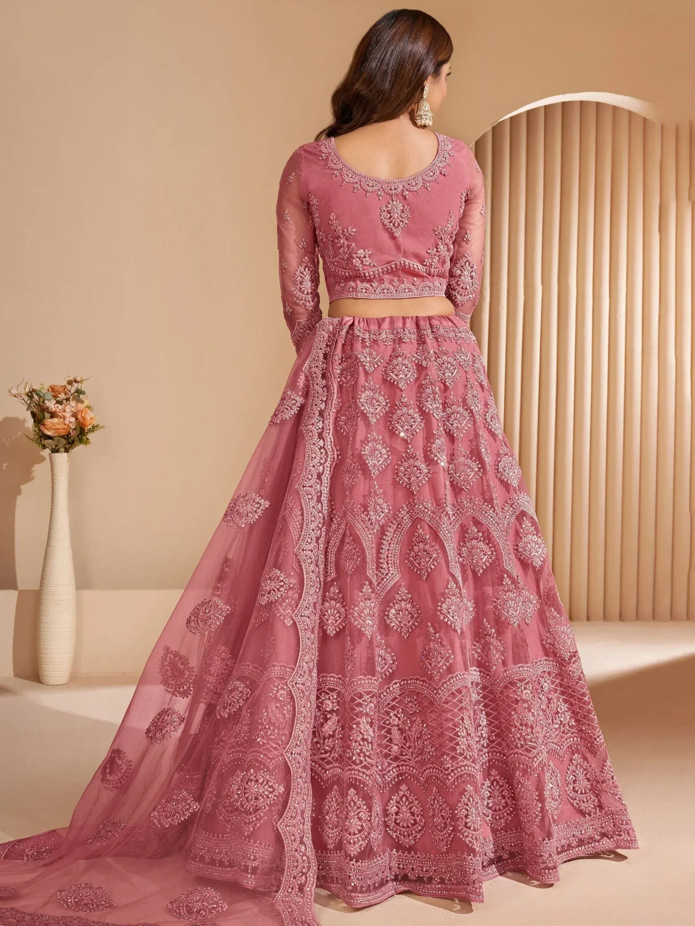 Pink embroidered lehenga choli with intricate floral motifs, perfect for Indian weddings and festive occasions.